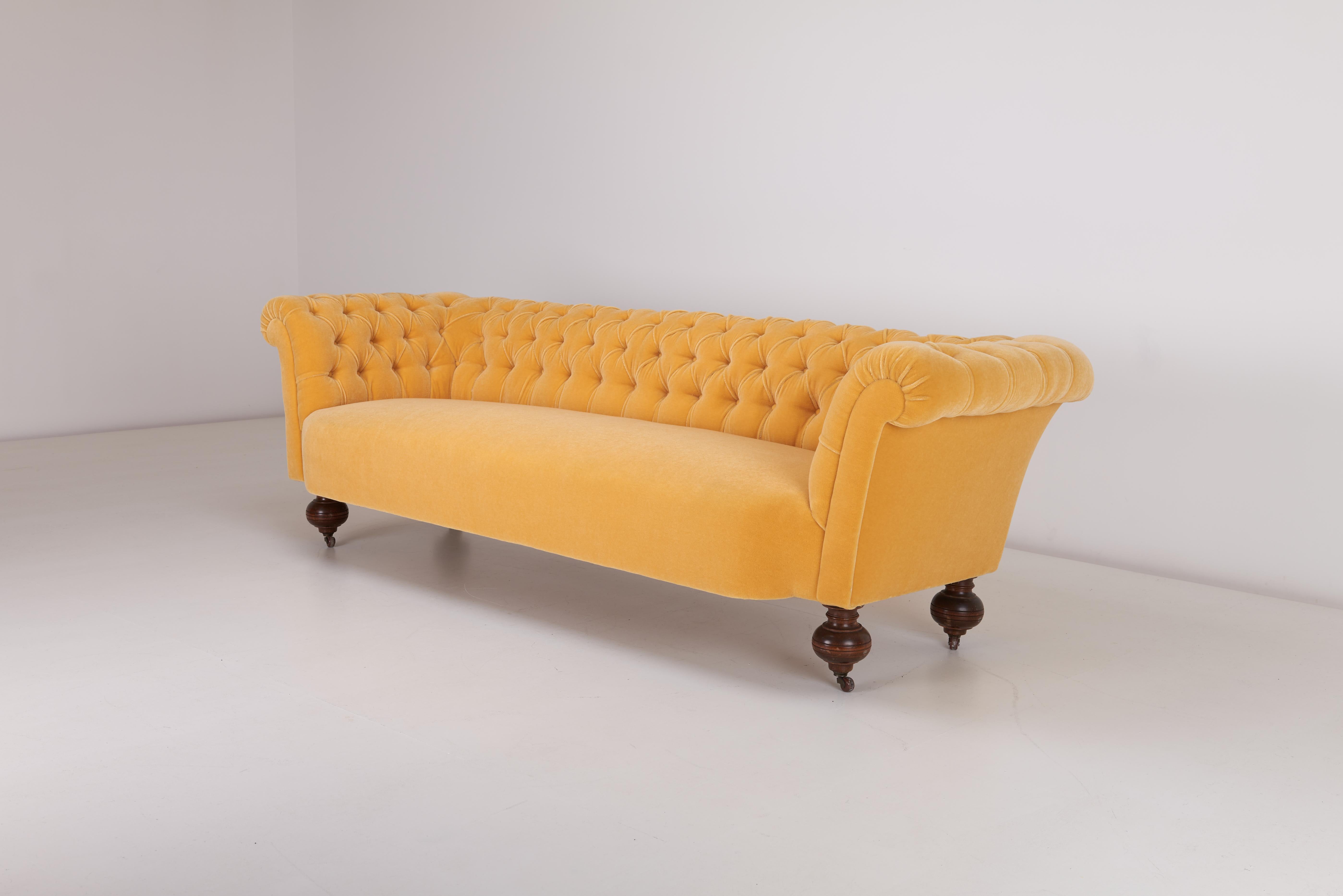 Cet exquis canapé Chesterfield suédois, datant du début des années 1900, offre à la fois un style luxueux et un savoir-faire intemporel. D'une longueur généreuse de 247 cm, il est recouvert d'un riche velours mohair jaune d'œuf de Rose Uniacke,