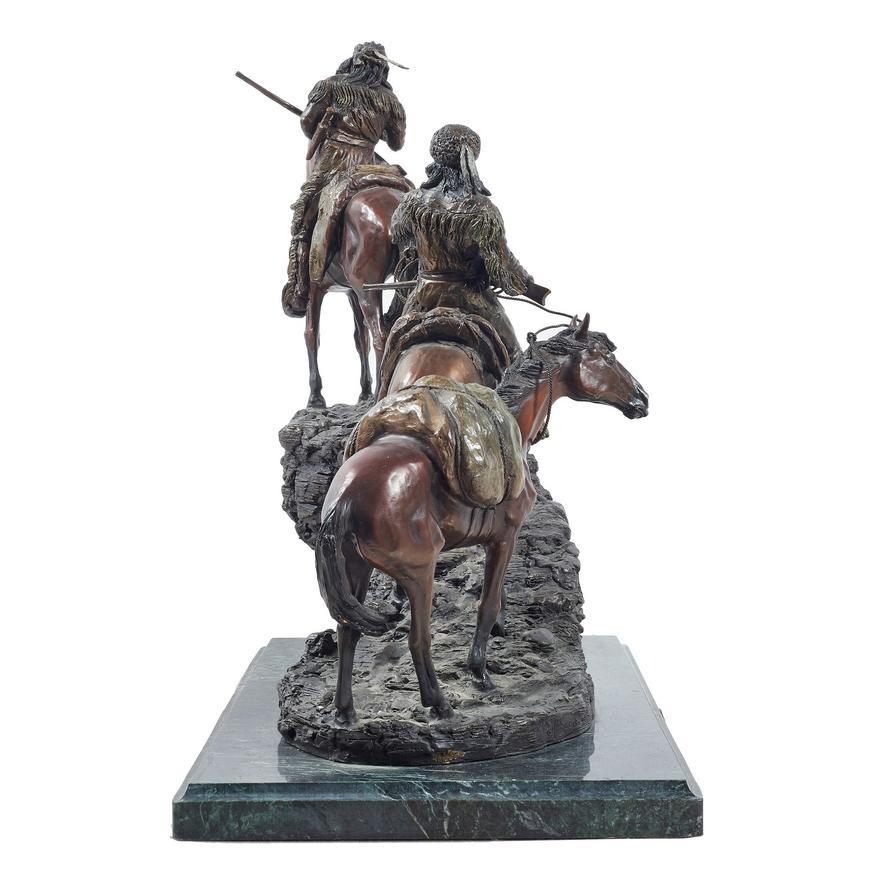 Presented is a bronze sculpture entitled Unknown Explorers by 20th century American artist Roy Harris. The bronze depicts two explorers, mounted on horses, riding up a rocky trail. The explorer in the back leads an unmounted pack horse behind him.