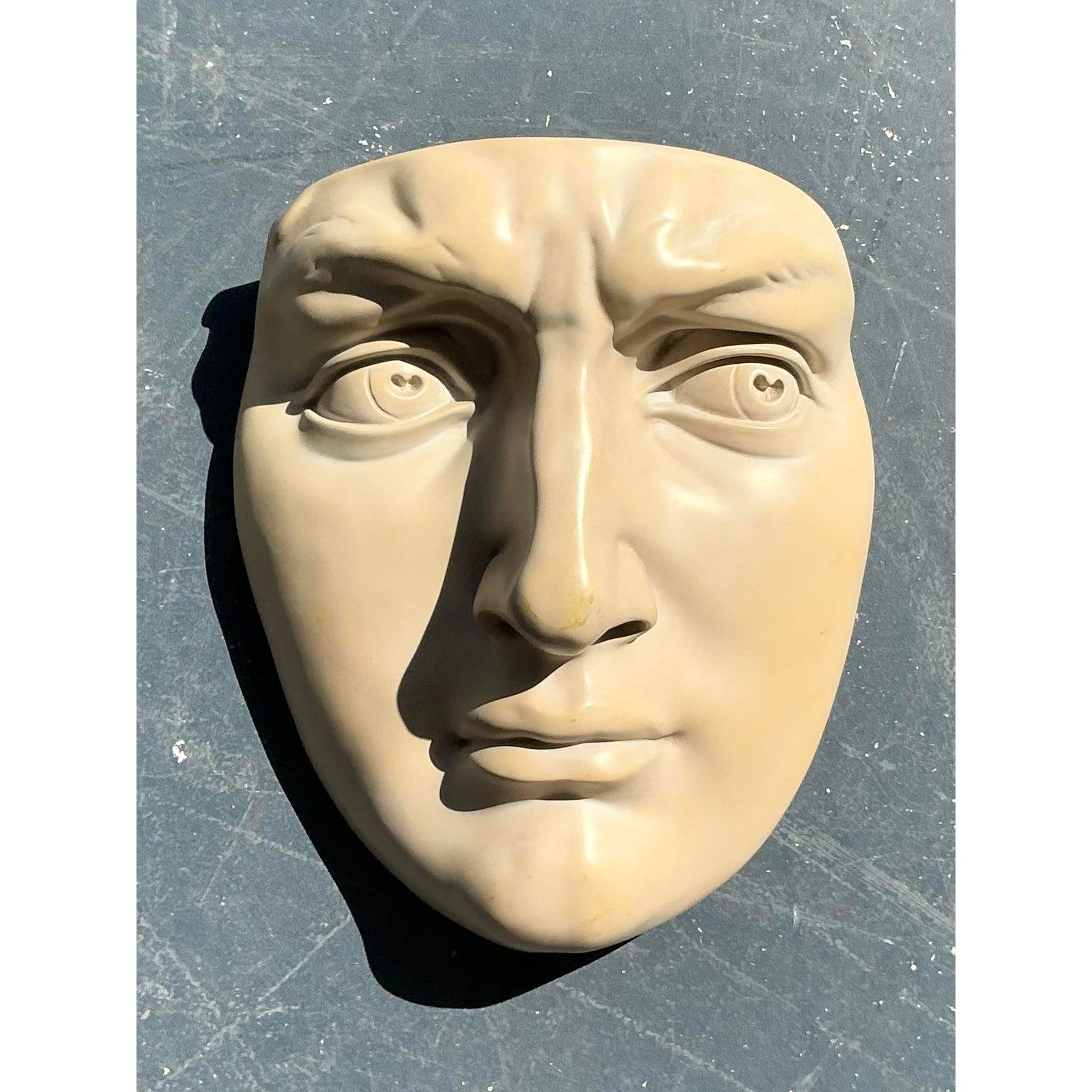 Questa intrigante coppia di maschere da parete vintage offre un cenno drammatico e scultoreo all'antichità classica, interpretata attraverso una lente artistica moderna. Realizzati in resistente resina stampata, questi pezzi ritraggono volti umani