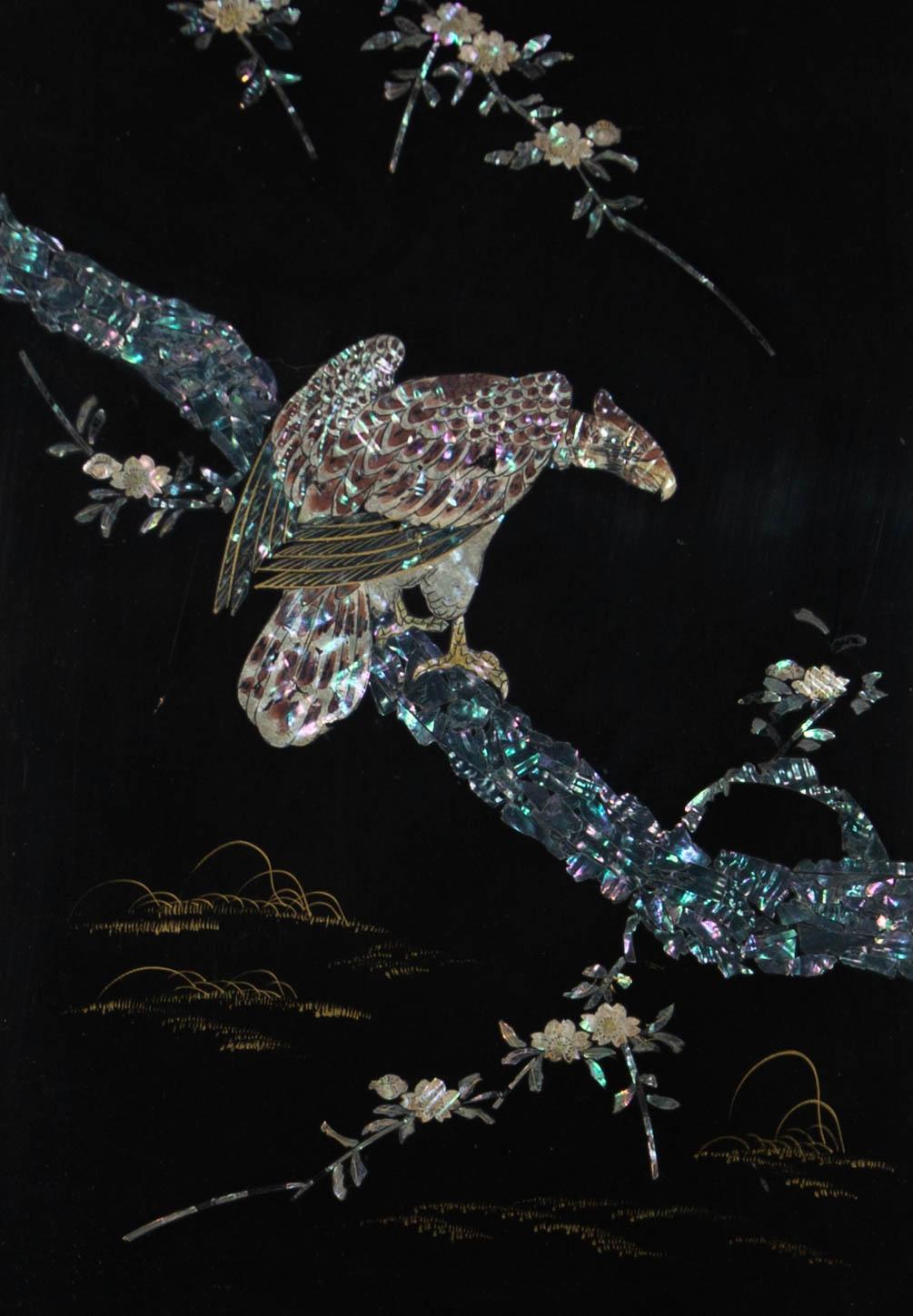 A mother of pearl, pen and ink and golden paint mixed media composition, depicting a bird of prey on a tree branch. Unsigned. Presented in a gilt-effect slip and in a wooden frame, as shown. On lacquer panel.