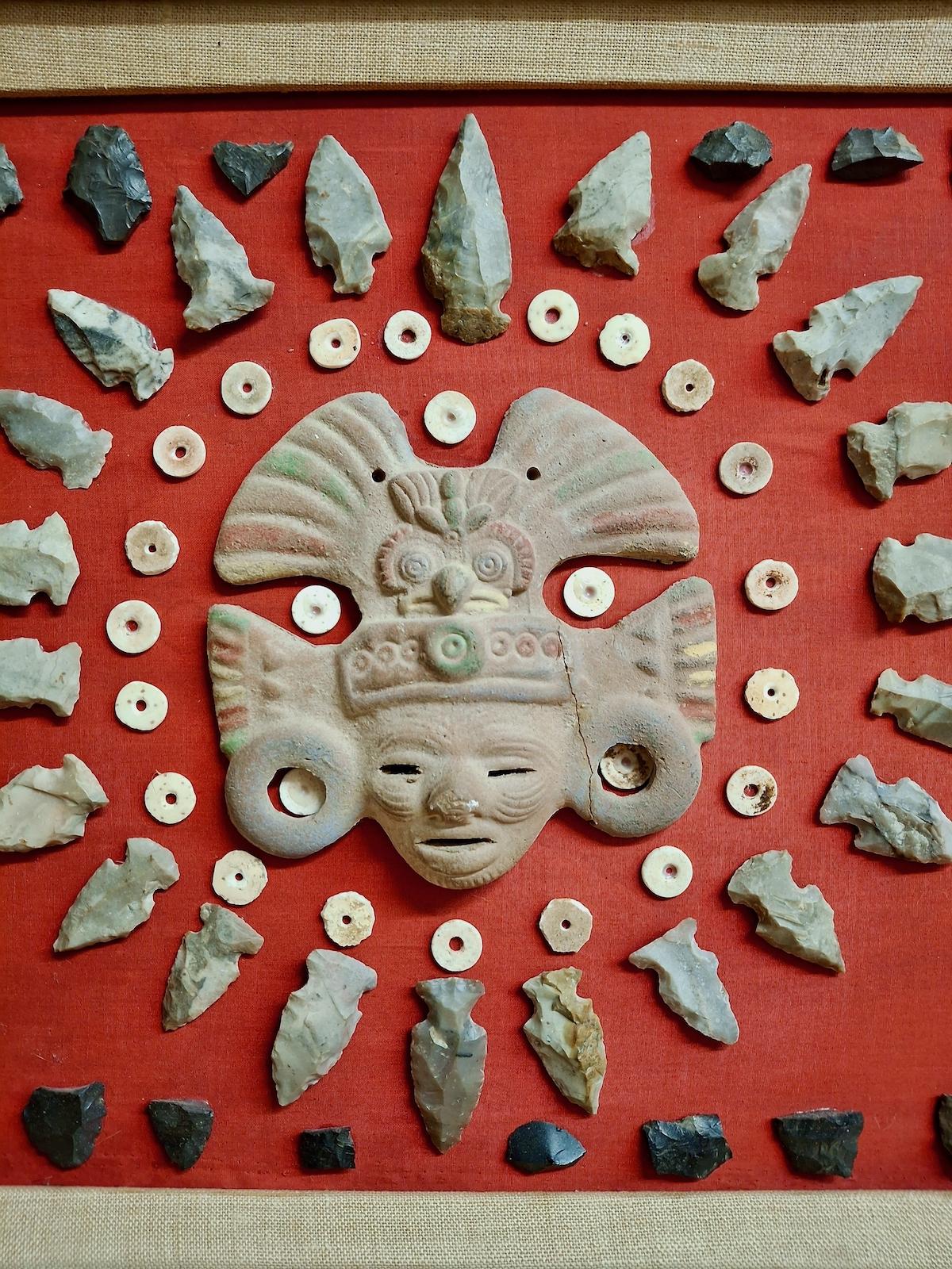 Au centre de cet assemblage d'éléments anthropologiques et naturels du XXe siècle se trouve une représentation en argile du visage d'un guerrier portant un masque d'aigle aztèque. Historiquement, un masque réel présentait un bec ouvert proéminent et