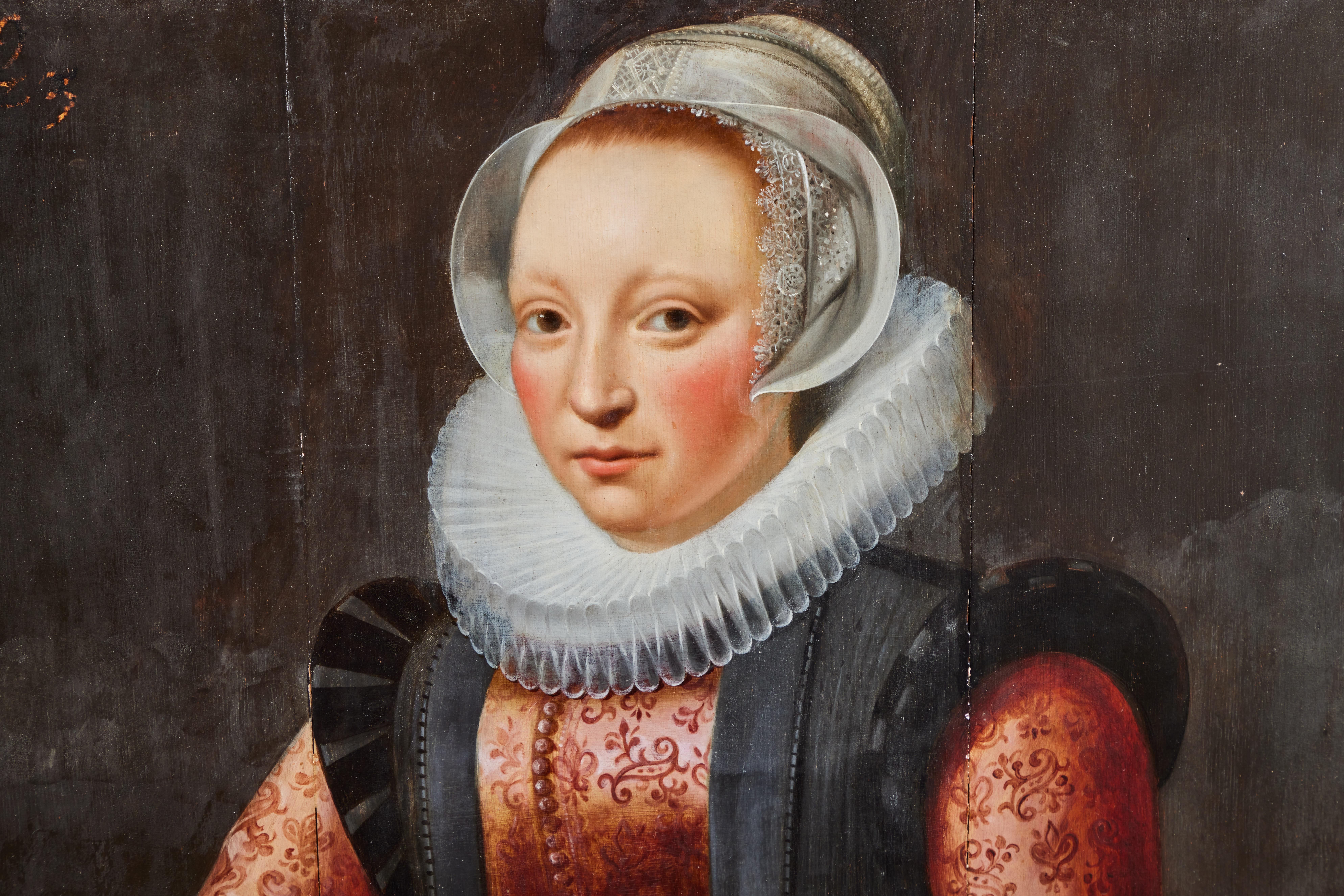 Une huile sur panneau de style baroque représentant une dame portant un haut brodé avec un col à volants. Son bonnet est bordé d'une délicate dentelle.
Daté de 1619 sur la partie supérieure gauche de l'avant du tableau. Le cadre en bois, gesso et
