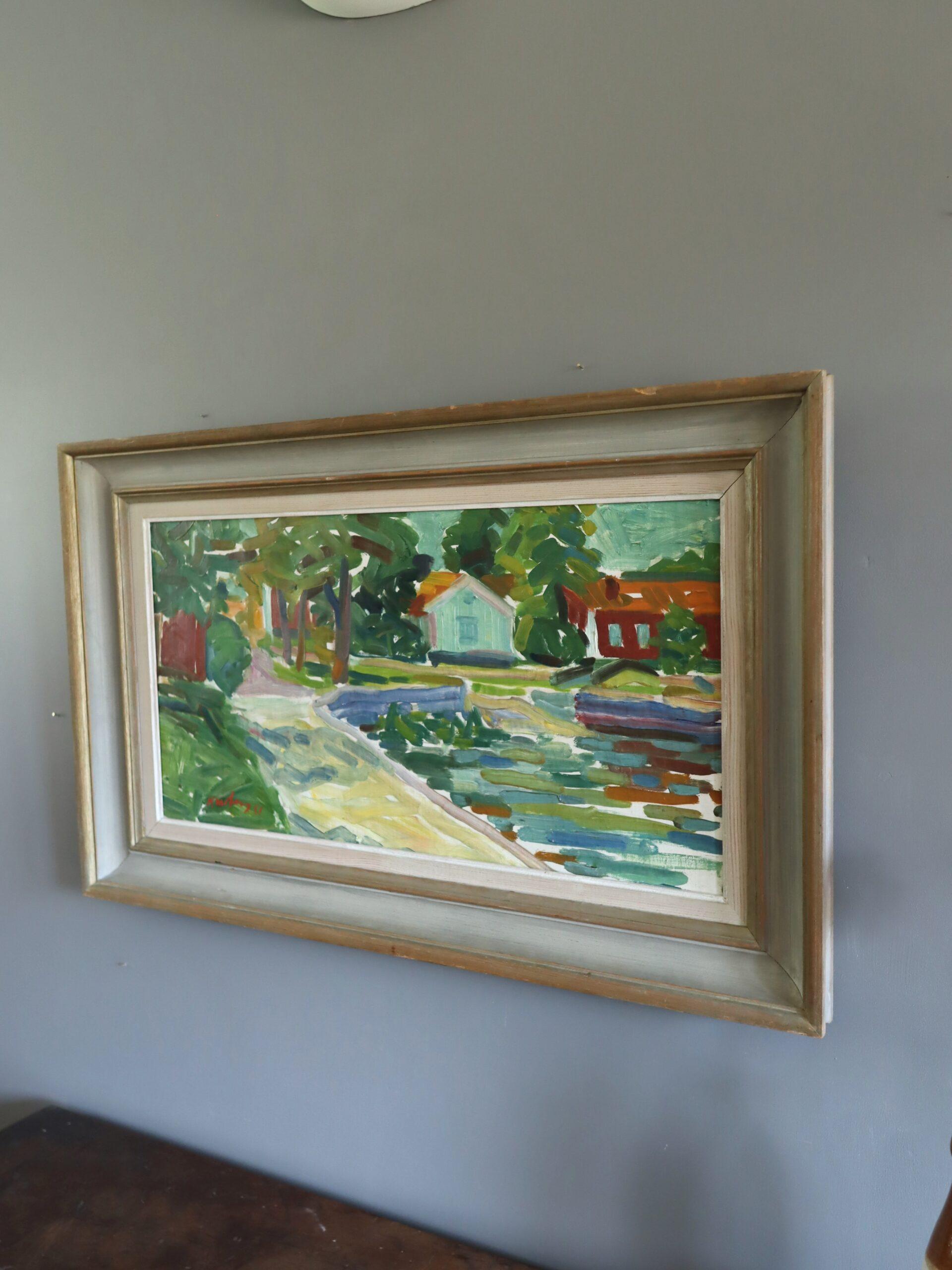 COTTAGES AU BORD DE L'EAU
Dimensions : 49 x 79 cm (cadre compris)
Huile sur toile

Une peinture vivante du milieu du siècle qui capture une scène tranquille au bord de la rivière, exécutée à l'huile sur toile et datée de 1951.

La composition