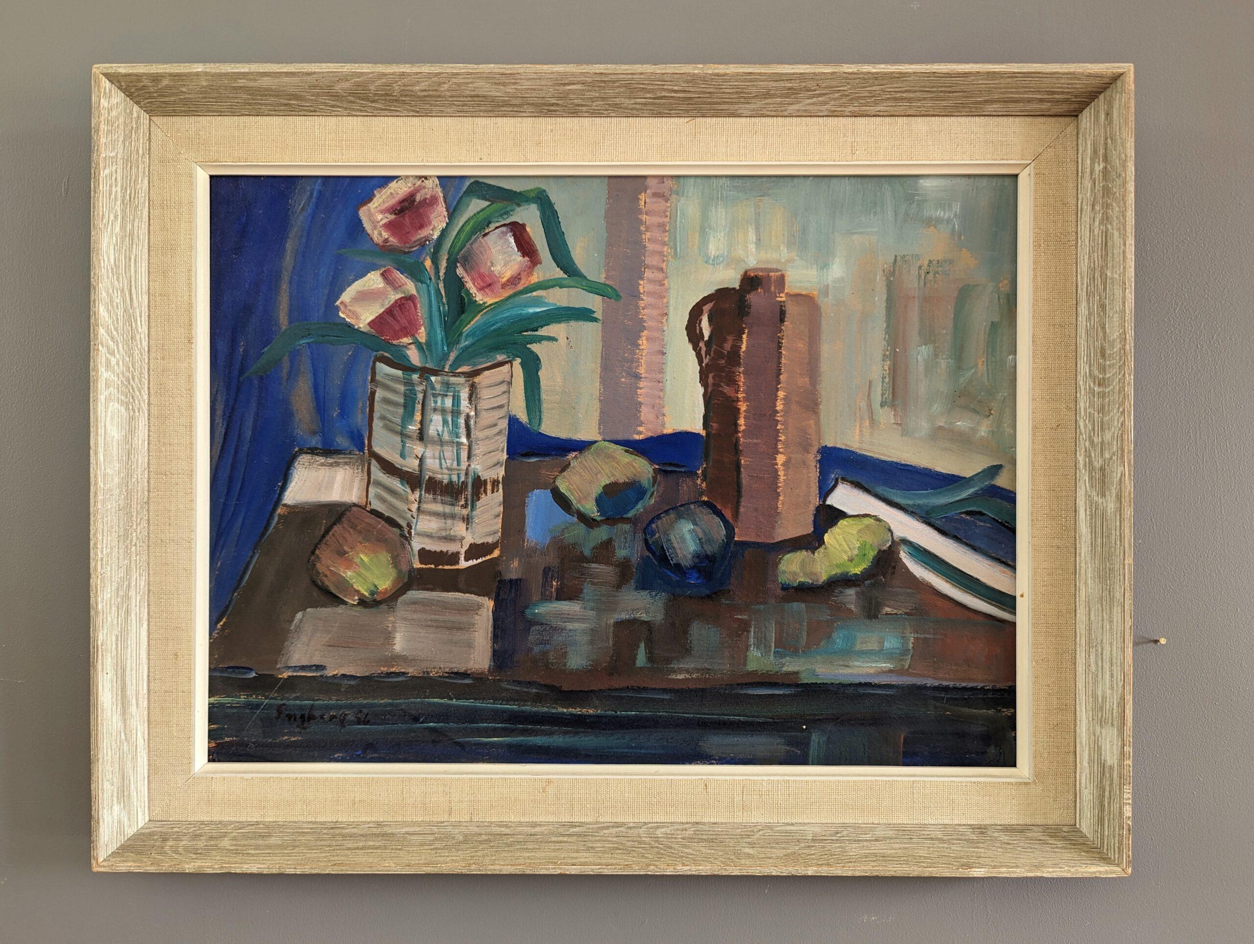 THE BLUE CLOTH
Size: 37.5 x 48 cm (including frame)
Oil on Board

A brilliantly executed mid-century modernist still life composition, painted in oil onto board and dated 1956.

The painting features an assortment of objects including a vase of red