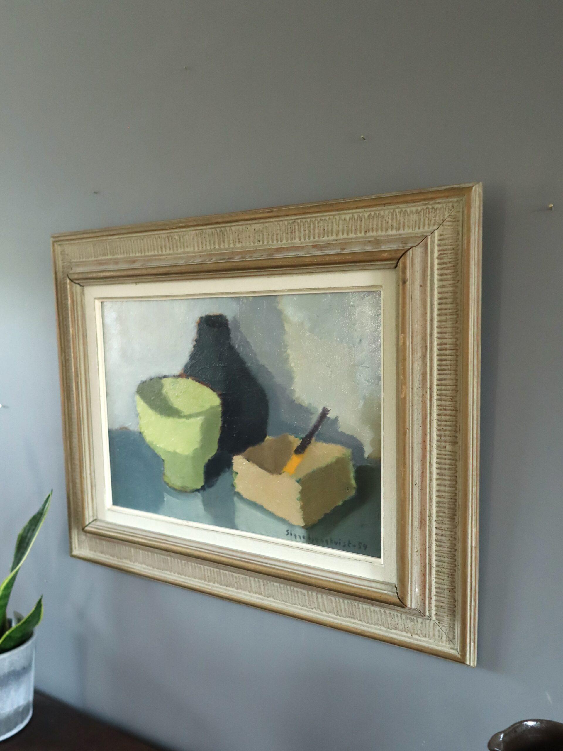 OGGETTI IN CONVERSAZIONE
Dimensioni: 50 x 62,5 cm (cornice inclusa)
Olio su tavola

Una calma e contemplativa natura morta di metà secolo che presenta una disposizione essenziale di oggetti di uso quotidiano resi con una tranquilla eleganza,