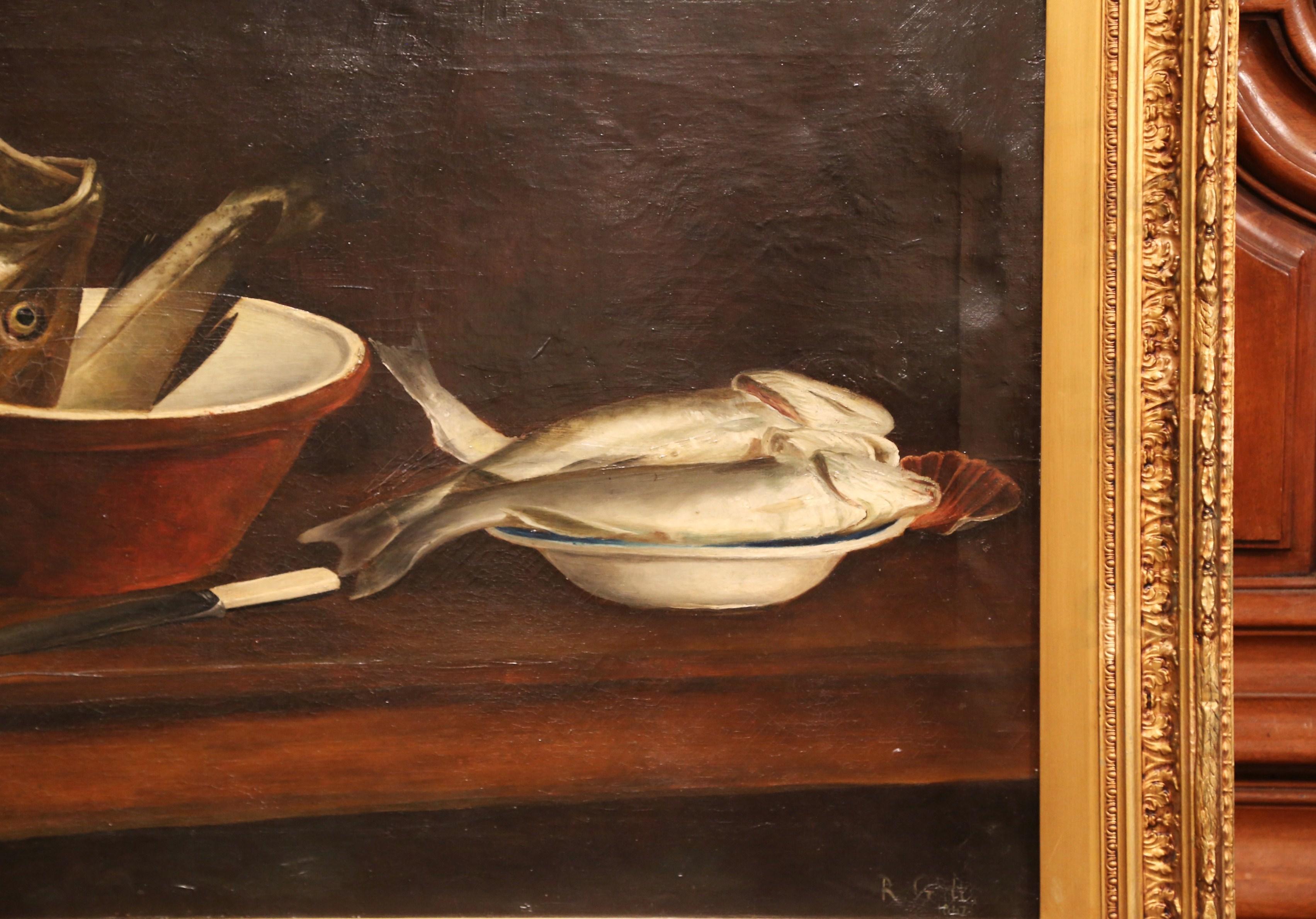 This antique, kitchen still life painting was painted in England in the 19th century. Signed on the bottom left corner and dated 1847, the canvas is set in its original carved gilt wood frame. The composition features two pots with fish that are