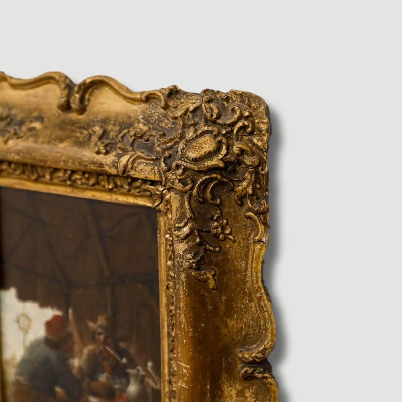 Cette peinture de genre intimiste représente des personnages réunis autour d'une table dans un abri faiblement éclairé, dans des tons chauds et terreux. L'œuvre est présentée dans un cadre doré orné de fioritures et de volutes sculptées dans le