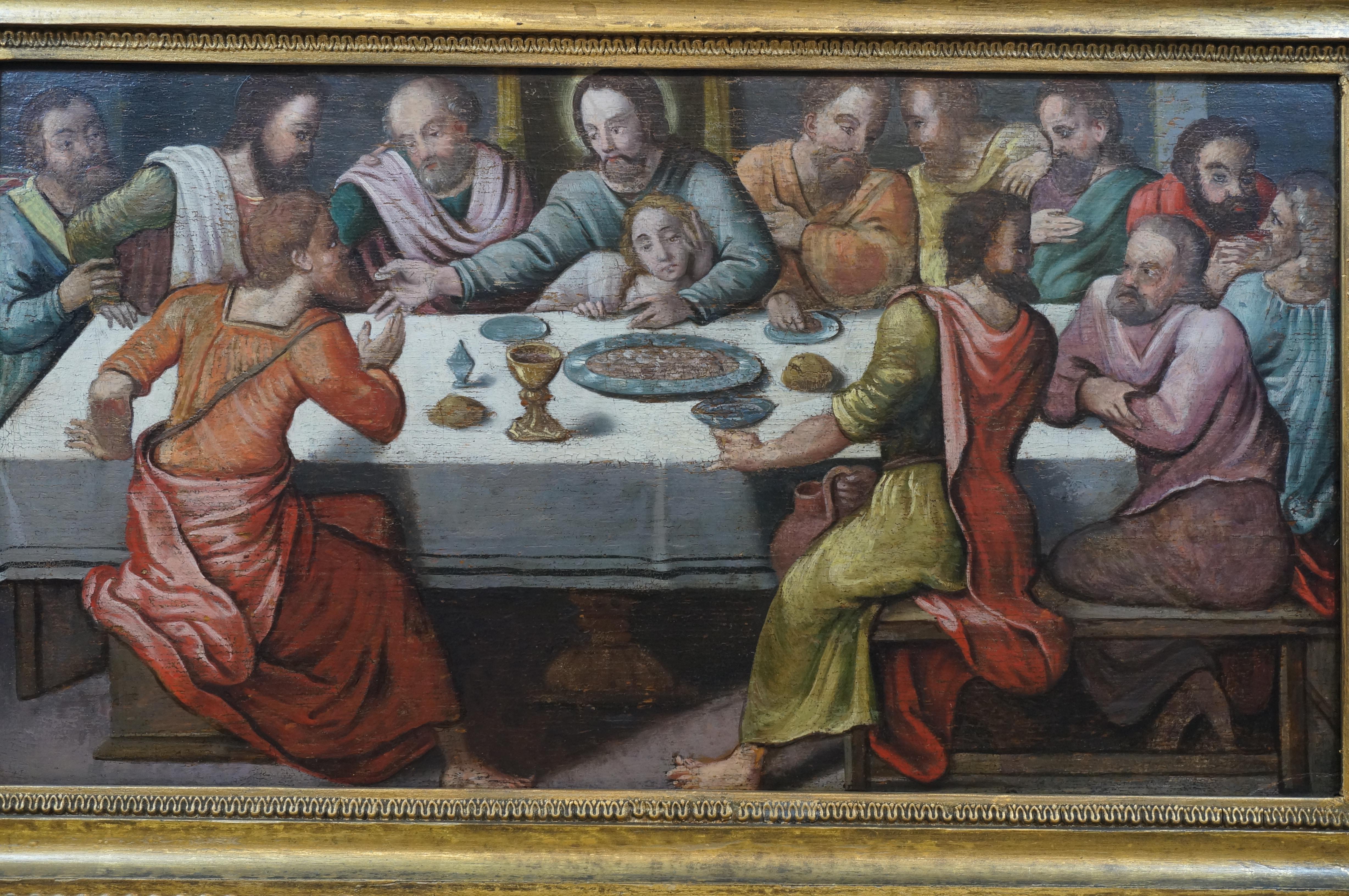 Archaic paiting of the Last Supper. Jezus surrounded by his twelve apostels seated around a table with a dish with a roasted lamb, a chalice in gothic style and pieces of bread.

The position of Saint John - in front of Jezus and resting upon his