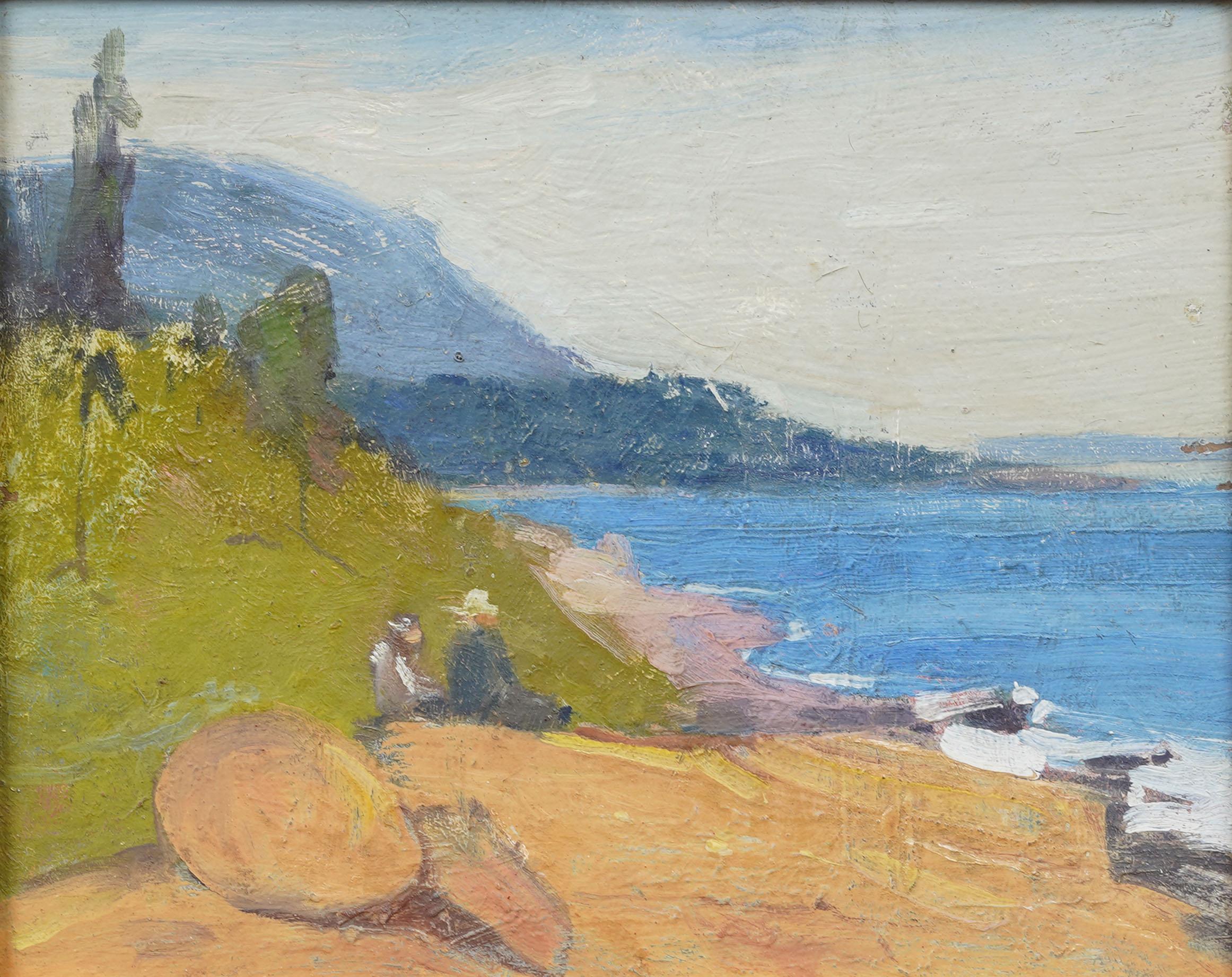 Charming early 20th-century impressionist oil on panel depicting a sunlit coastal scene. Two seated figures rest along a grassy bluff, overlooking calm blue waters where small boats are drawn up on shore. Loose, painterly brushwork captures the