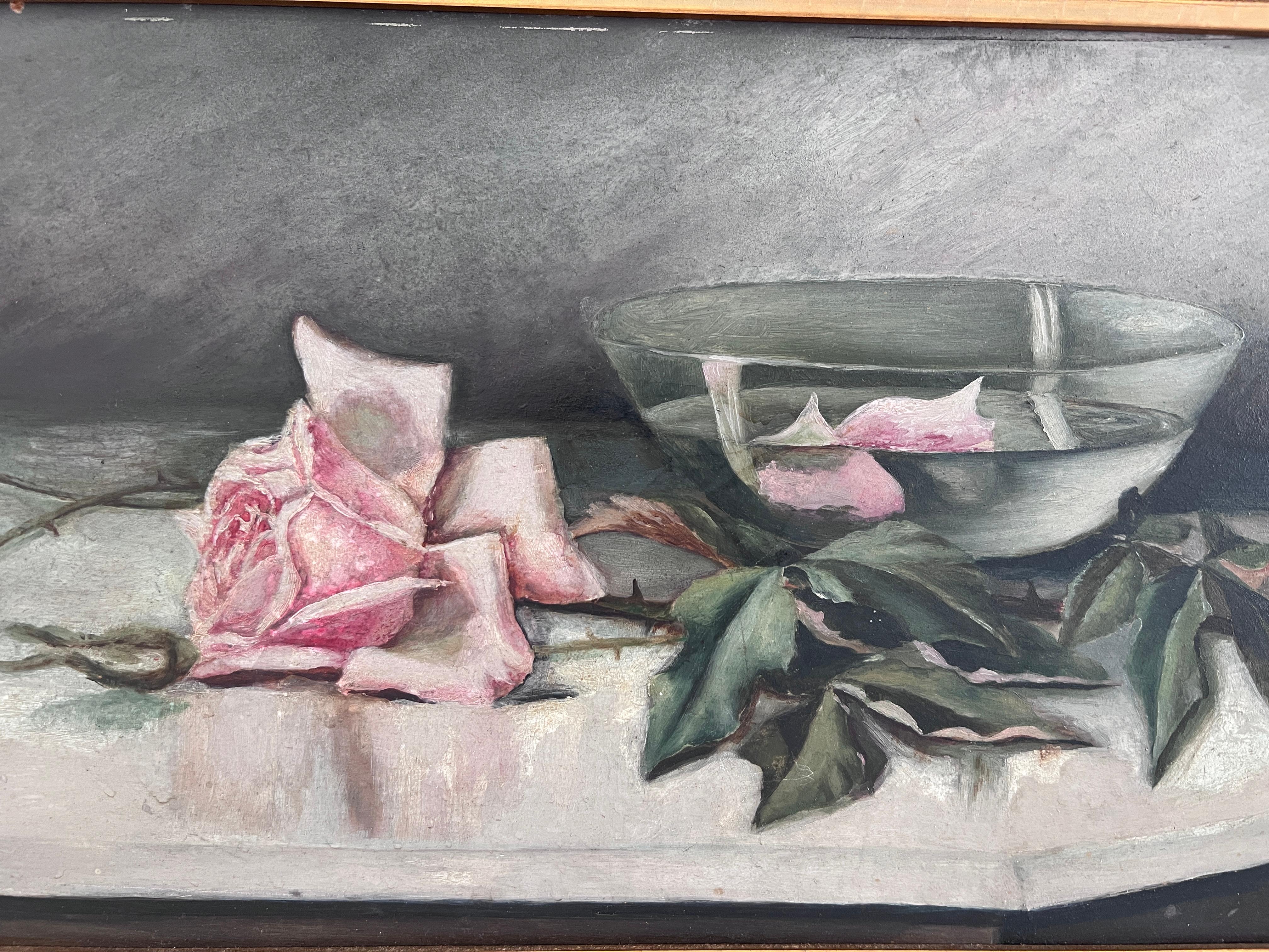 A hauntingly delicate antique still life oil painting on board, this unsigned piece features a soft, moody composition of a pink rose, fallen petals, and a green glass bowl with water. The work evokes quiet melancholy with its dark background and