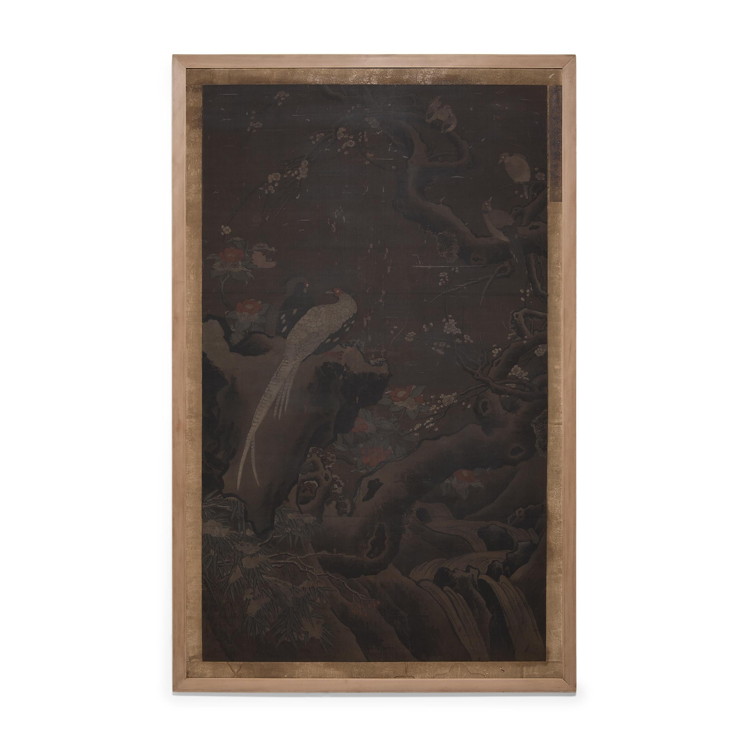 A grand example of Chinese calligraphy painting, this large bird-and-flower painting dates to the late Ming dynasty (1368-1644) and depicts a quiet winter scene of two silver pheasants surrounded by plum blossoms, camellia, and snowy bamboo.