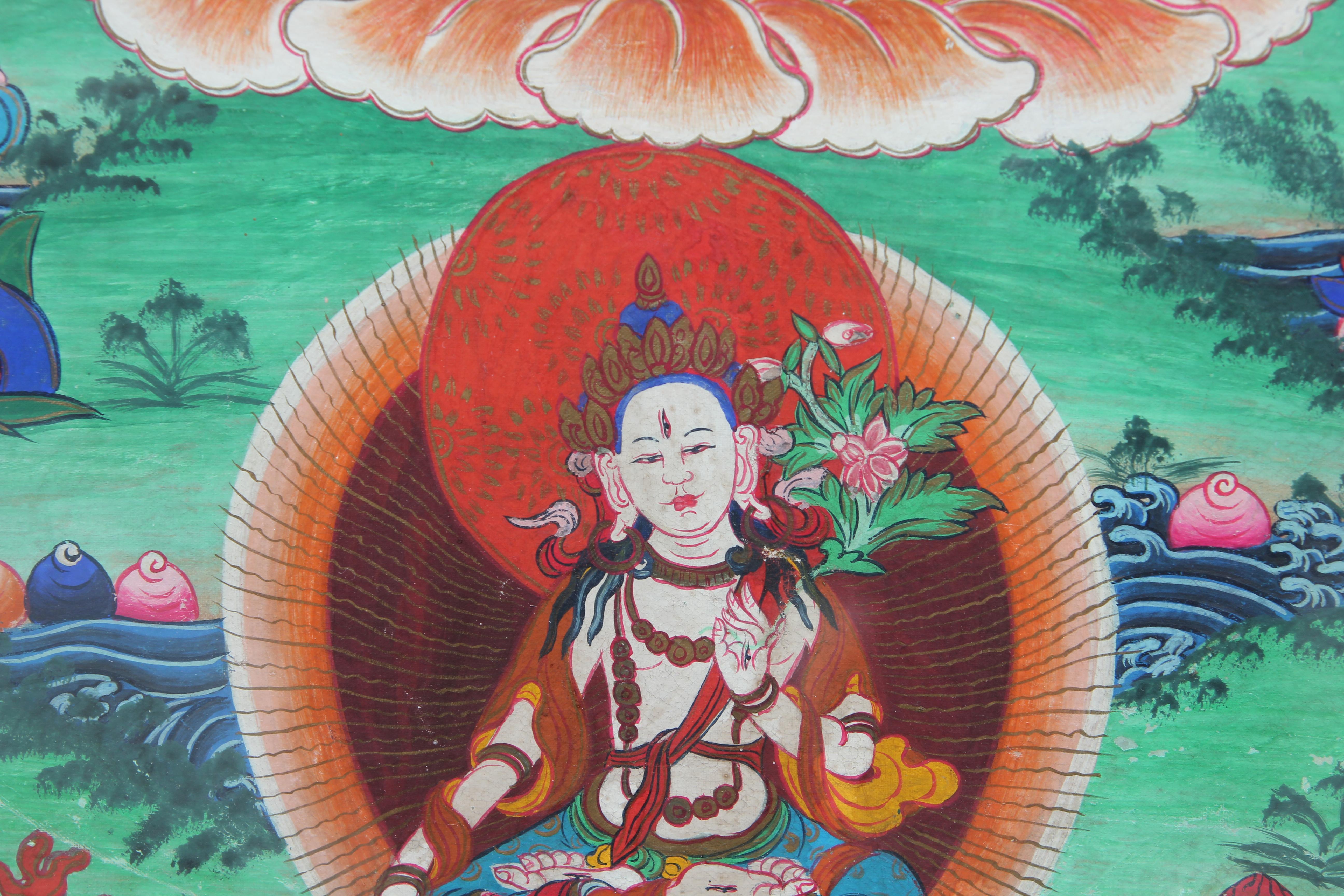 Thangkas are devotional paintings used in by Buddhists in their homes, in monasteries, or temples. The main body, Lokeshwor, is white with 1000 arms and 1000 eyes and symbolizes infinite compassion. The red, green, blue, and orange pigments on the