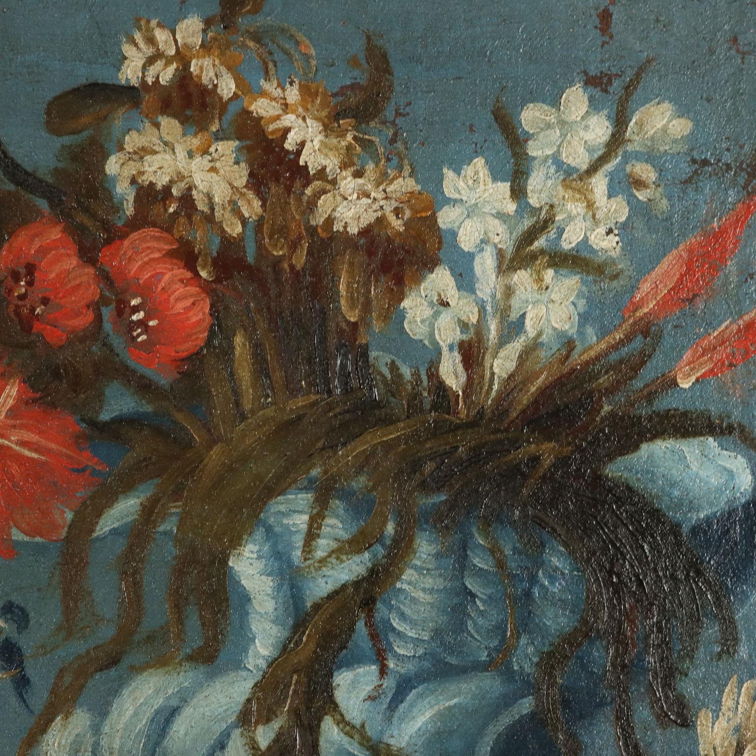Öl auf Leinwand. 
Lebendige Natur Komposition  von bunten Blumen in blauen Keramikvasen, die die Farbe des Himmels im oberen Teil des Hintergrunds widerspiegeln, der dann im unteren Teil zu einer erdigen Farbe verblasst; links sticht ein