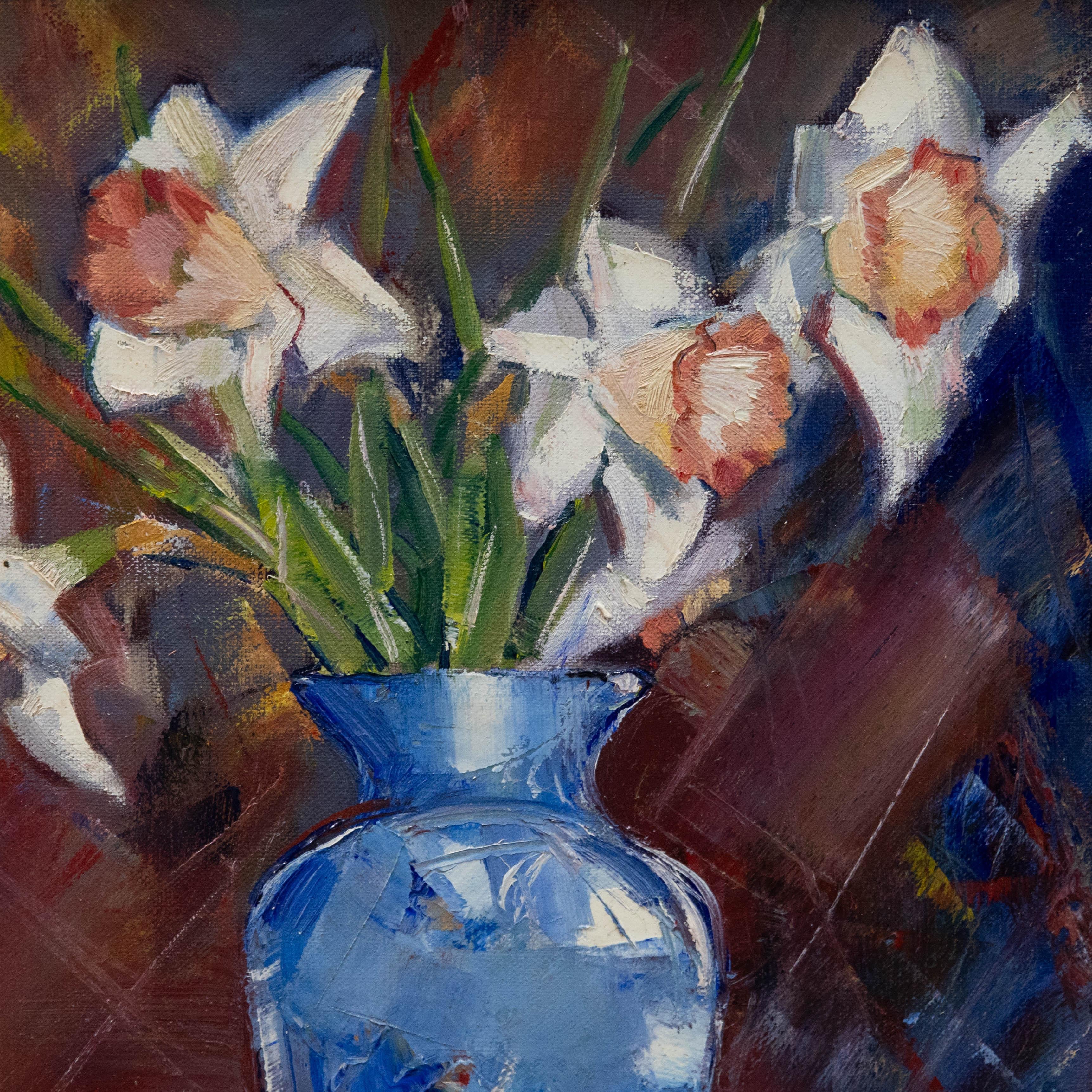 Eine eindrucksvolle Stillleben-Szene des zeitgenössischen Künstlers Douglas Hutton. Hier hat die Künstlerin eine schöne blaue Vase mit Frühlingsnarzissen eingefangen. Eine kleine gelbe Schale und zwei Äpfel ruhen am Fuß der Vase in knackigen Falten