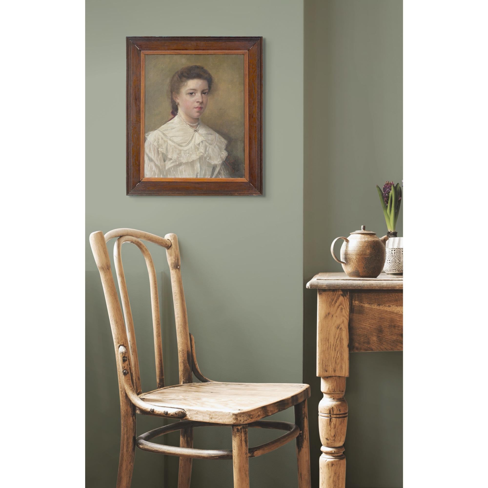 Cette huile sur toile du début du XXe siècle représente une jeune femme portant une robe blanche et un collier de perles.

Lorsque ses parents ont commandé ce portrait vers 1900, il s'agissait d'un événement monumental. Pouvez-vous imaginer ce