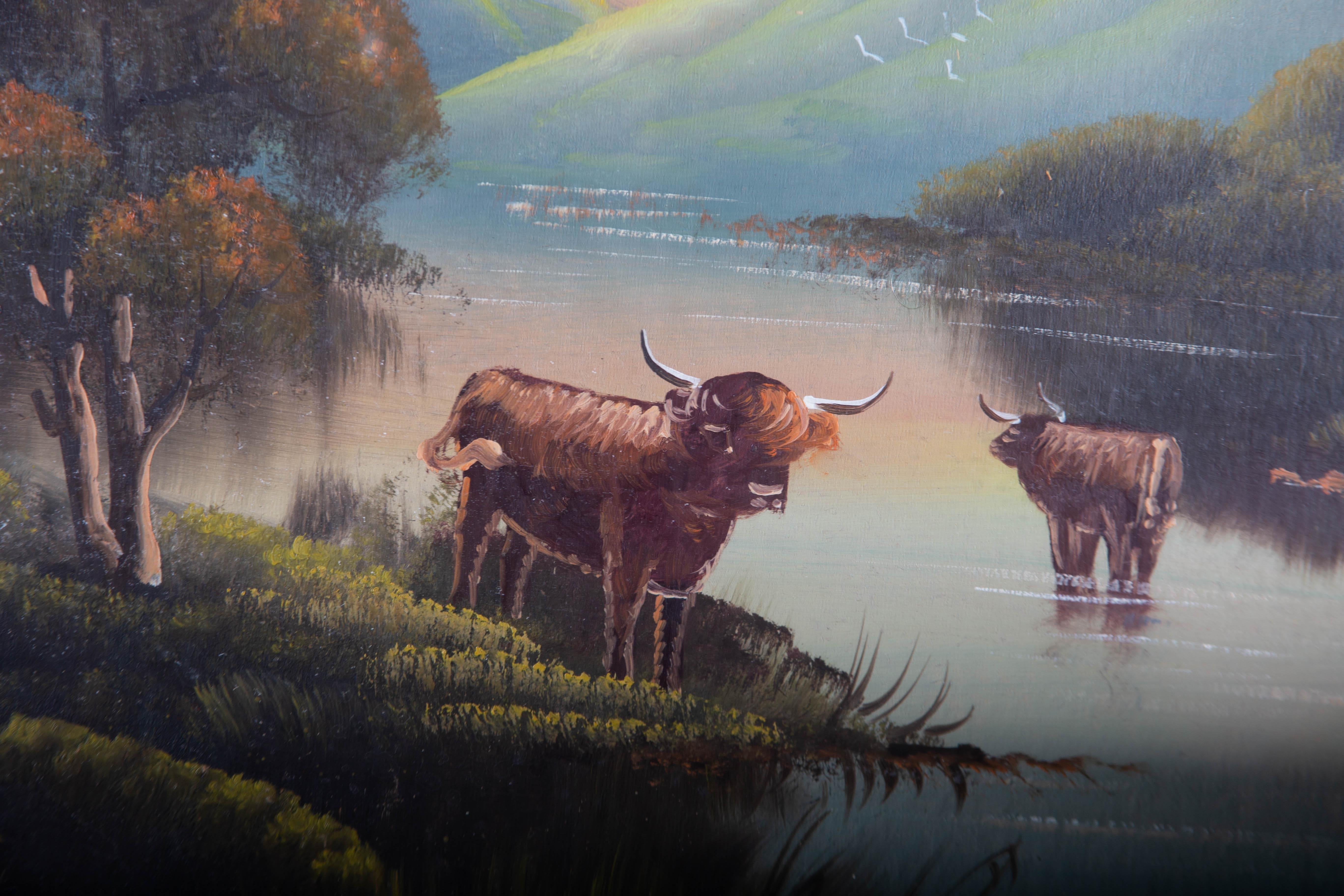 A charming highland scene showing two highland cows standing in the shallows of an expansive lake with verdant banks, under a blushing sunset. The artist has signed illegibly to the lower edge and the painting has been handsomely presented in its