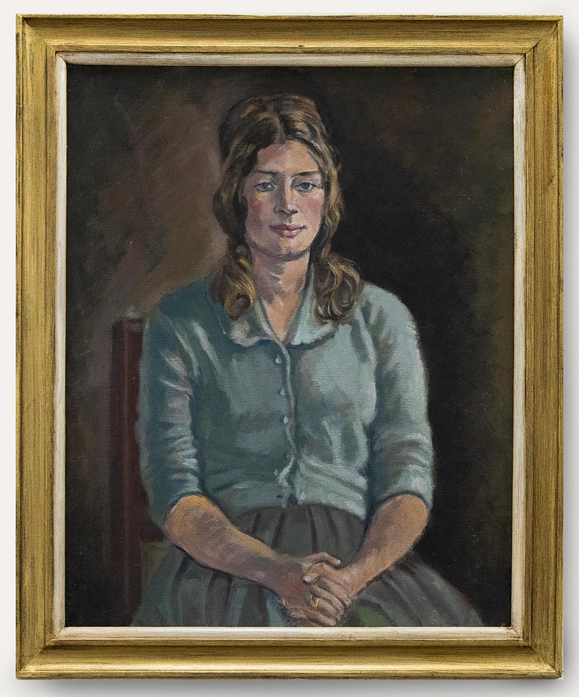 Ein charmantes Ölporträt einer sitzenden jungen Dame in hellblauer Strickjacke und Faltenrock. Gut präsentiert in einem vergoldeten Holzrahmen mit einem weißen Innenfenster. Nicht signiert. Auf Leinwandkarton.