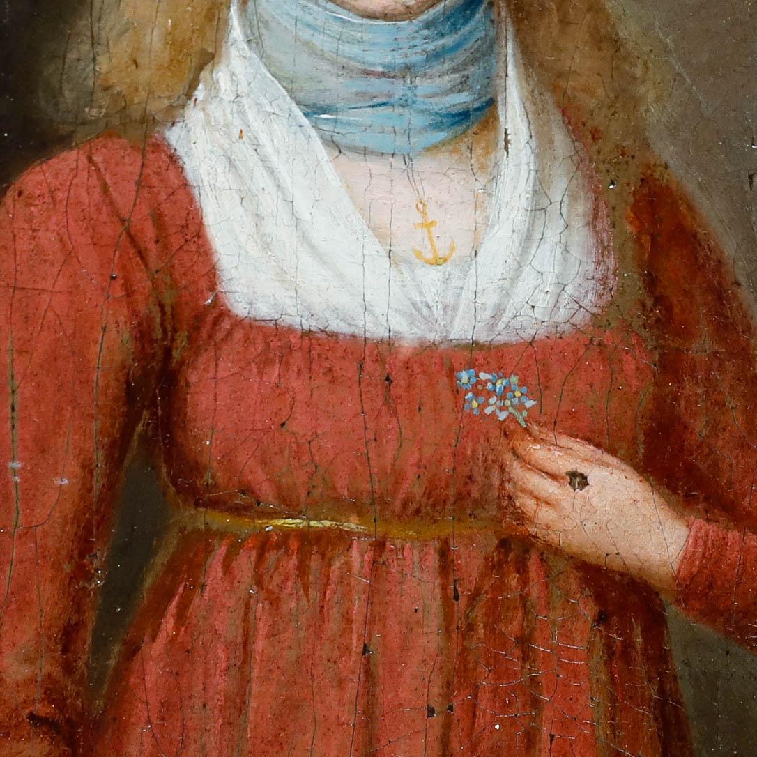 A charming example of early 19th-century French folk art depicting a young woman in a striking red dress. Symbols throughout the composition suggest the woman is a sailor's wife. Wearing an anchor pendant around her neck and holding forget-me-nots