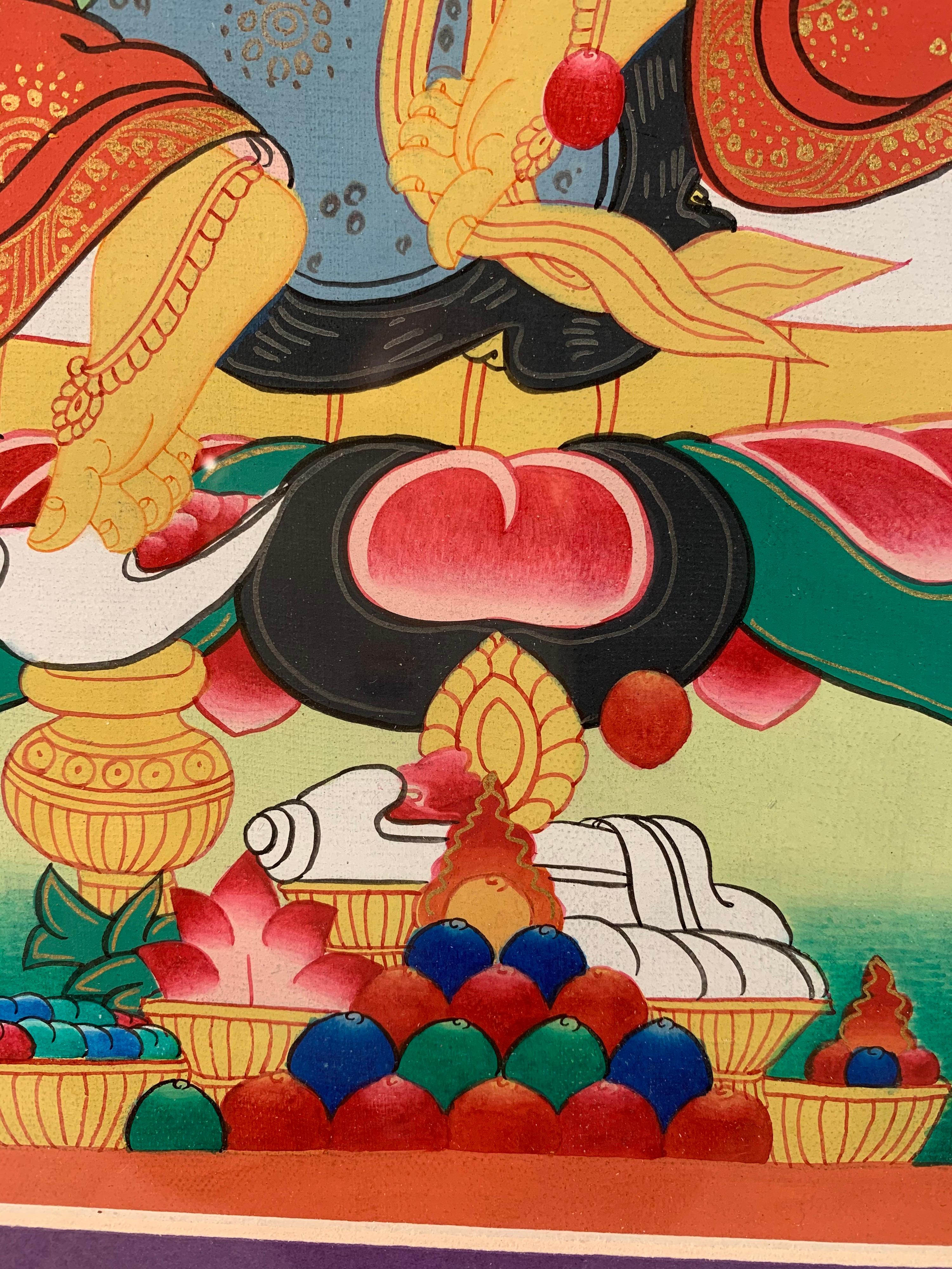 This is a framed, hand painted thangka of Jambhala or Kubera on canvas with 24 carat gold.
Jambhala is seated in easy pose with one hand holding a jewel and another a mongoose. Jambhala is also known as Kubera or Vaishravana, the deity of wealth. He