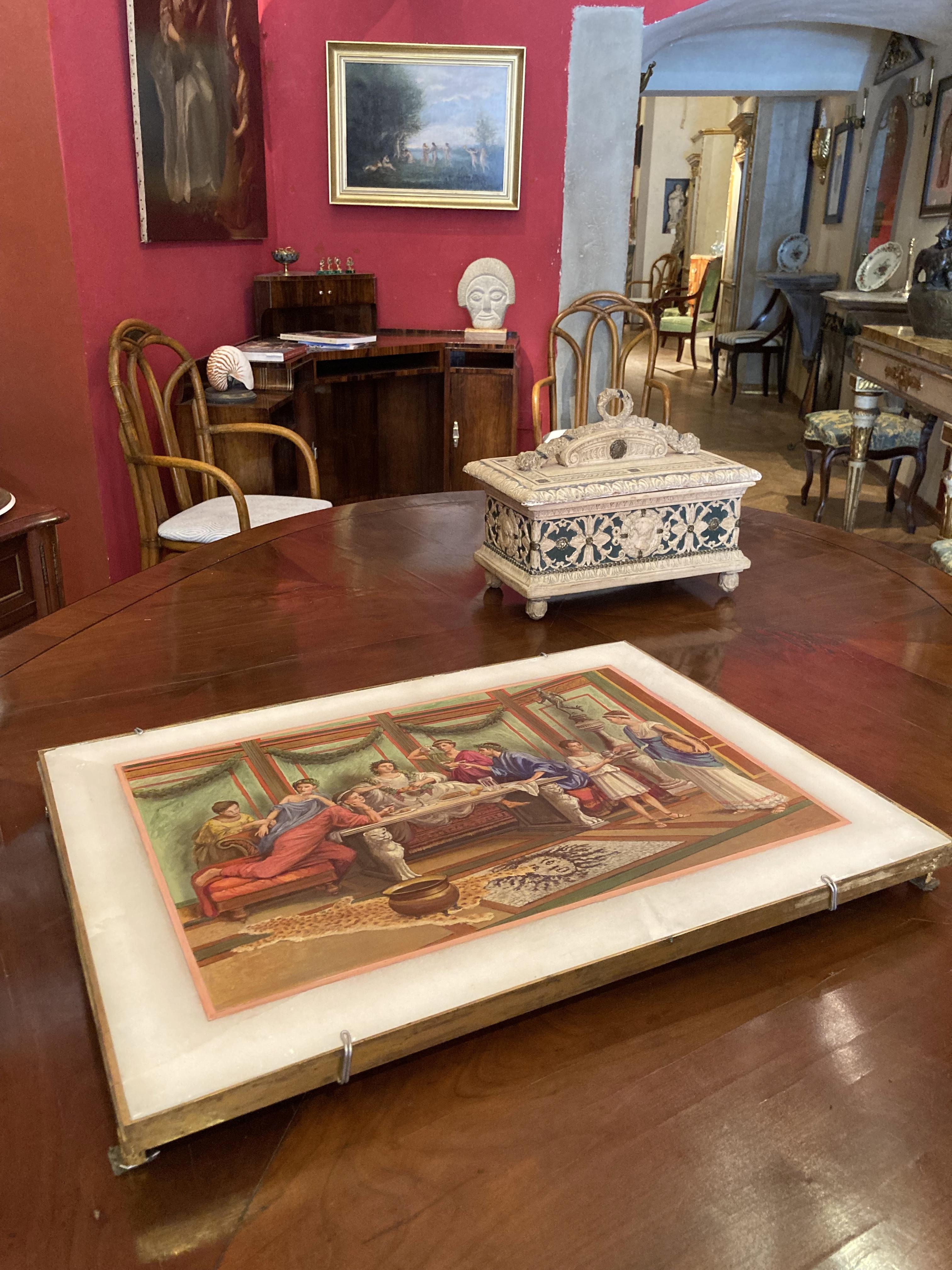 Cette huile sur albâtre italienne du XIXe siècle représente un intérieur opulent de style néoclassique pompéien avec des gens en train de festoyer.
La scène intérieure figurative est peinte sur une plaque d'albâtre rectangulaire et placée dans un