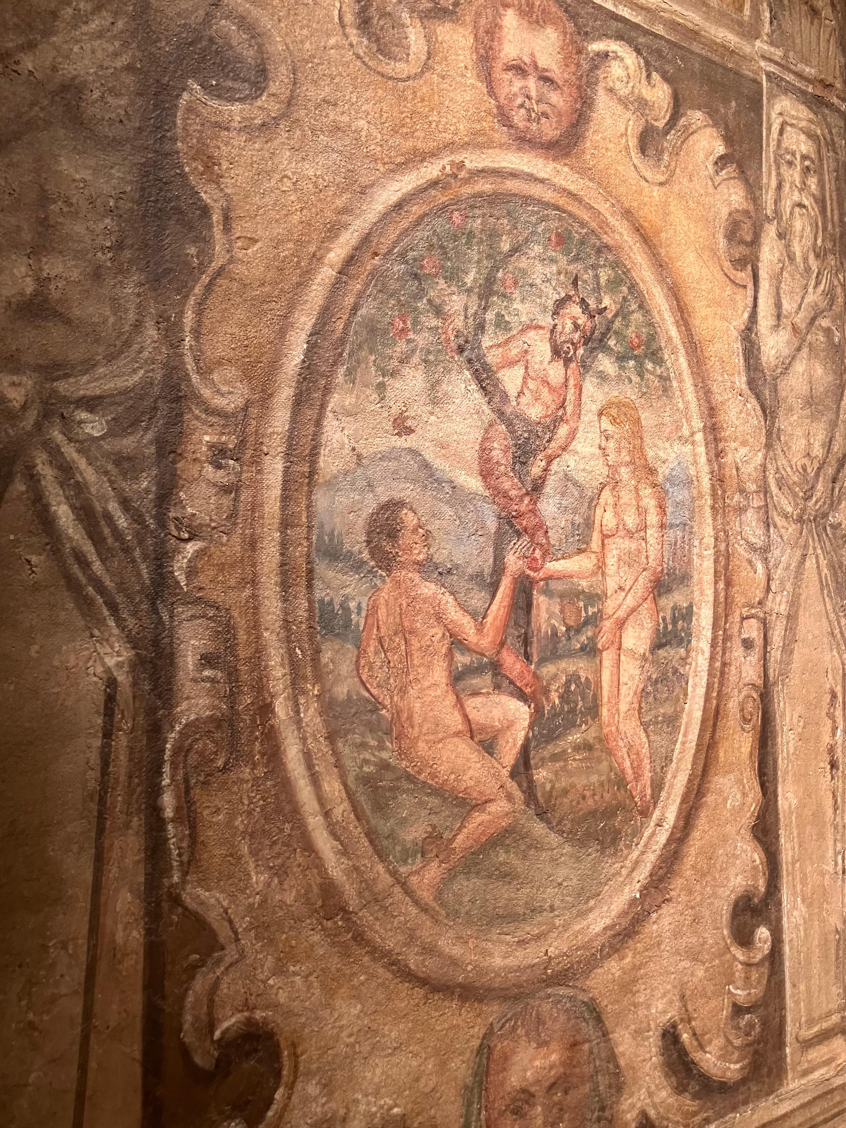 This art piece is a Florentine Renaissance period fresco of late 1500 hand painted with egg tempera representing the temptation of Adam and Eve, this pivotal moment in the history of genesis is framed in an oval scrolled cartouche and flanked by