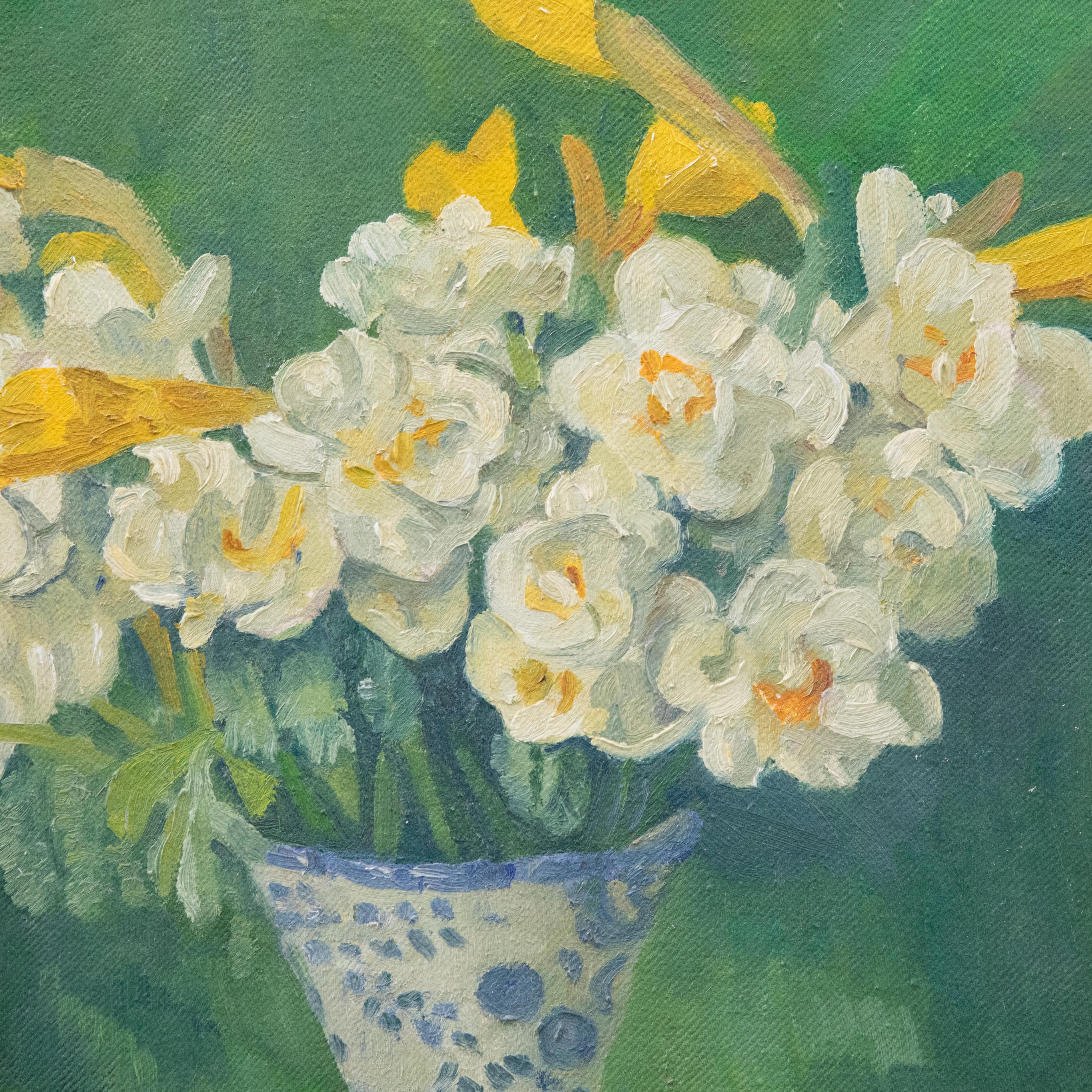 Un delizioso studio di natura morta che raffigura dei narcisi in un vaso di porcellana blu e bianco. L'artista abbina i narcisi a uno sfondo verde intenso, facendo risaltare il giallo vibrante dei fiori. Firmato in basso a destra. Presentato in una