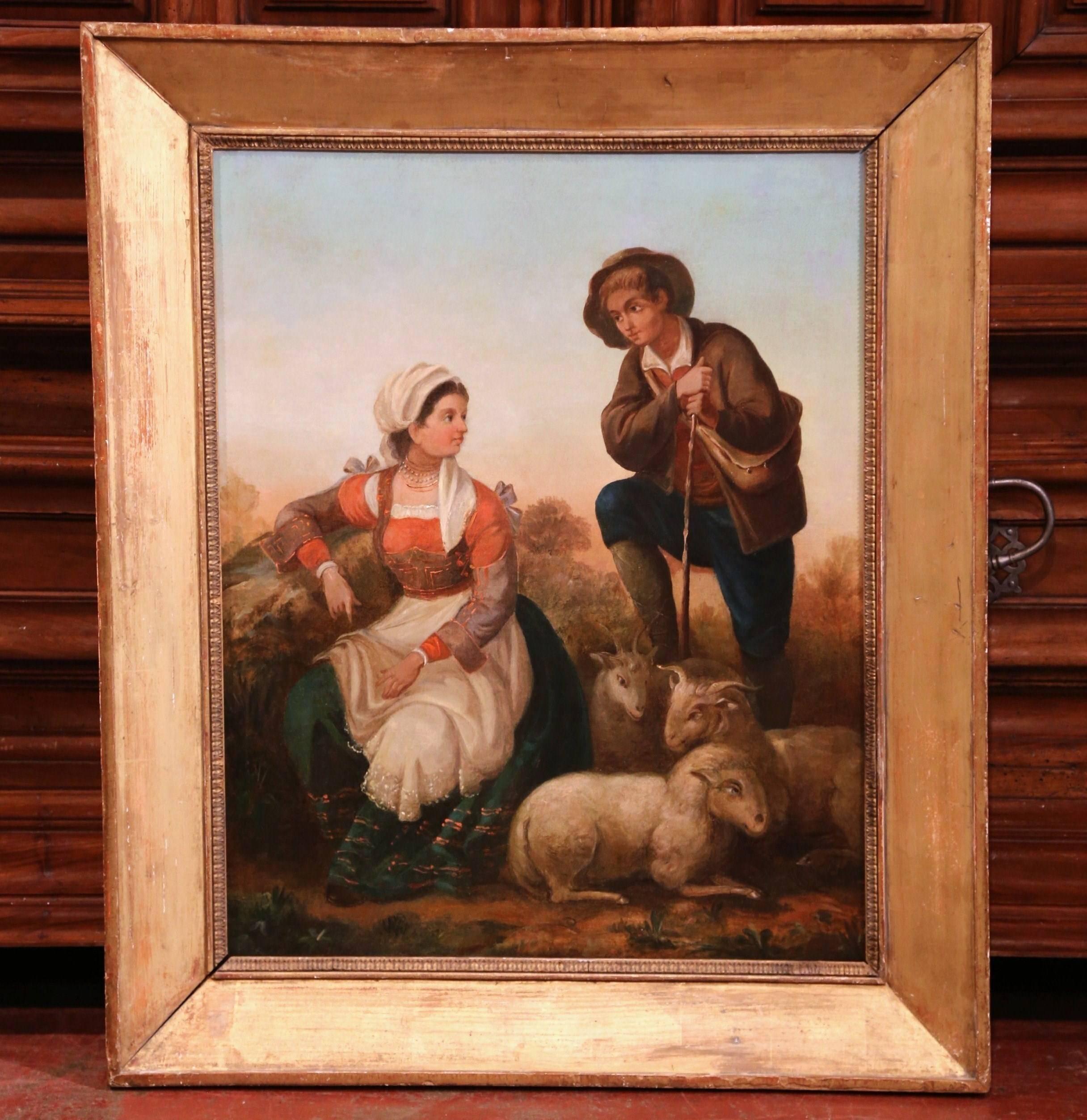 This beautiful oil on canvas was painted in France circa 1850. The colorful painting illustrates a rustic scene with a shepherd courting a young girl, while tending to his sheep. The two figures are set in a countryside landscape, and are dressed in