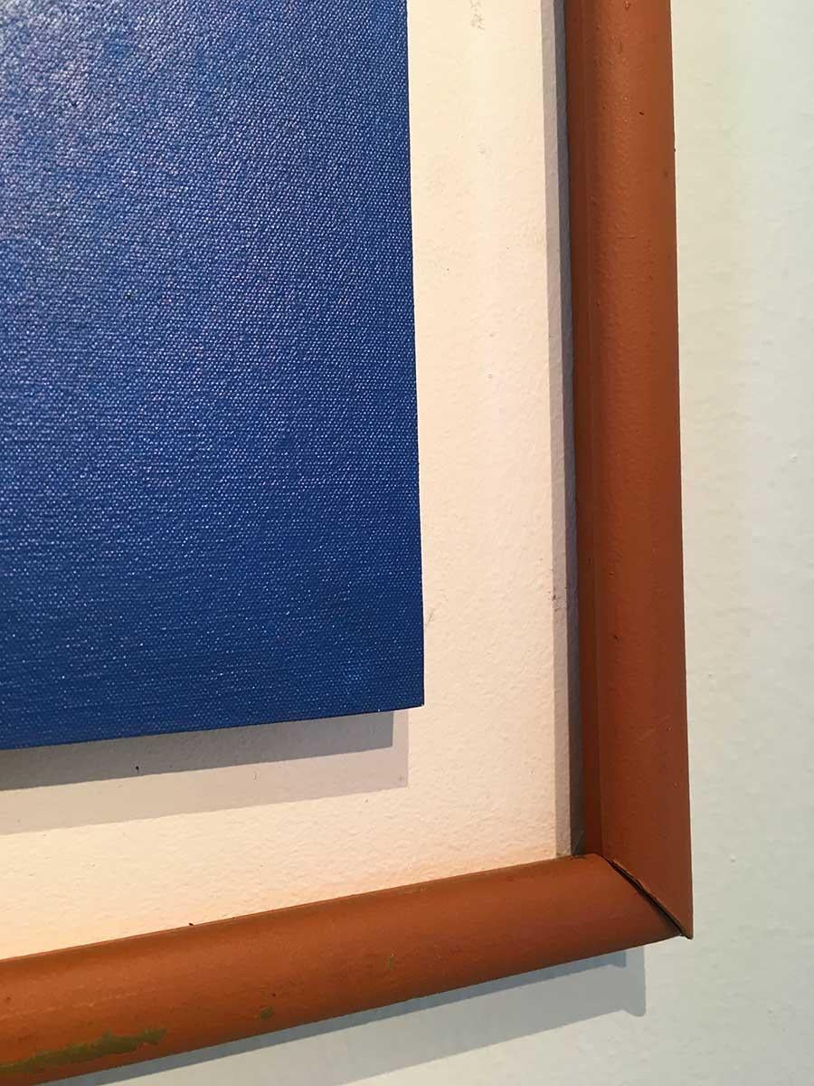 Este vívido bodegón al óleo sobre tabla de inspiración pop, obra de un pintor colombino desconocido, muestra tres limones amarillo ácido en un primer plano sobre un campo de brillante azul cobalto. La escala de los limones sobre el fondo muy