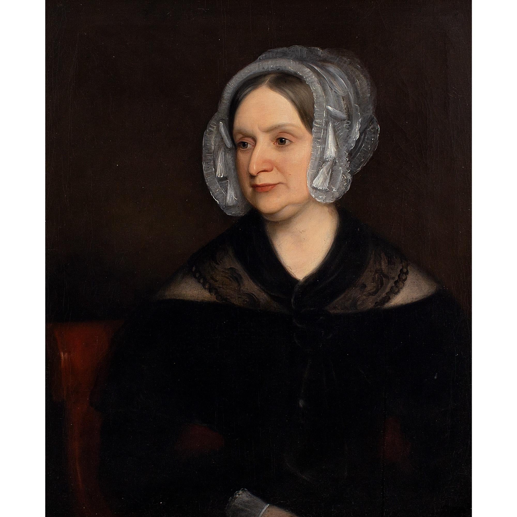 This fine mid-19th-century English school portrait depicts a lady wearing a black dress and white bonnet. She’s probably dressing according to the rules relating to mourning wear.

During the 19th century, widows were expected to adhere to a set of