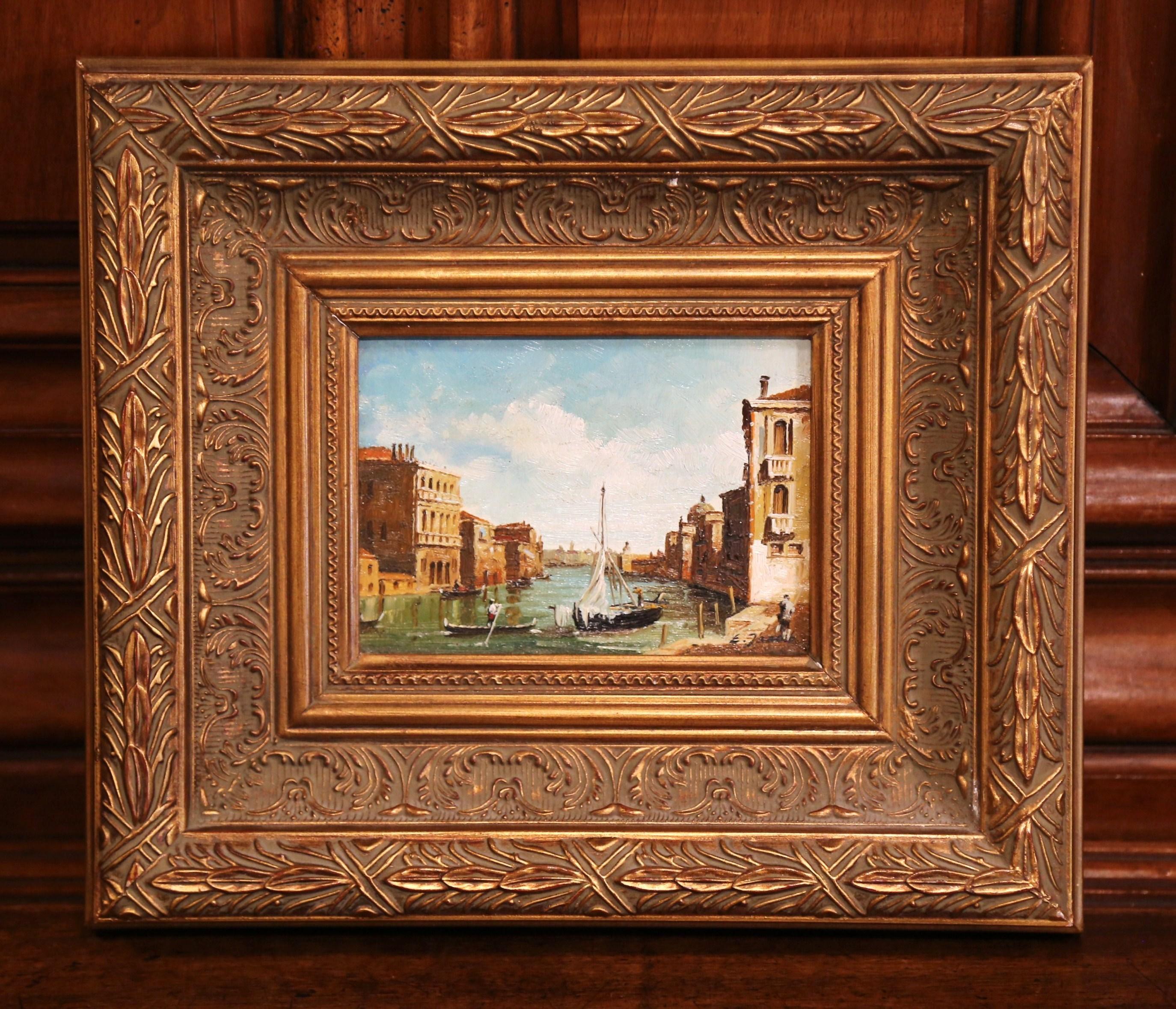 This colorful vintage oil on canvas painting was created in Italy, circa 1960. Set in an ornate gilt frame, the painting depicts a harbor scene with old structures on both sides. The lively features boats and sailboat under a beautiful sunset. The