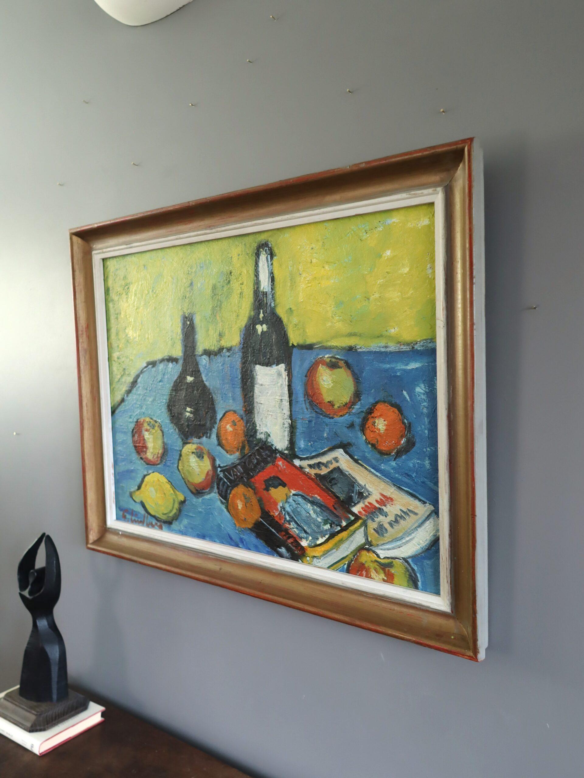 CITRON ET LITTÉRATURE
Taille : 56 x 72,5 cm (cadre compris)
Huile sur carton

Une nature morte vivante et expressive du milieu du siècle dernier qui capture une scène de table animée où fruits, bouteilles et livres convergent dans une symphonie de