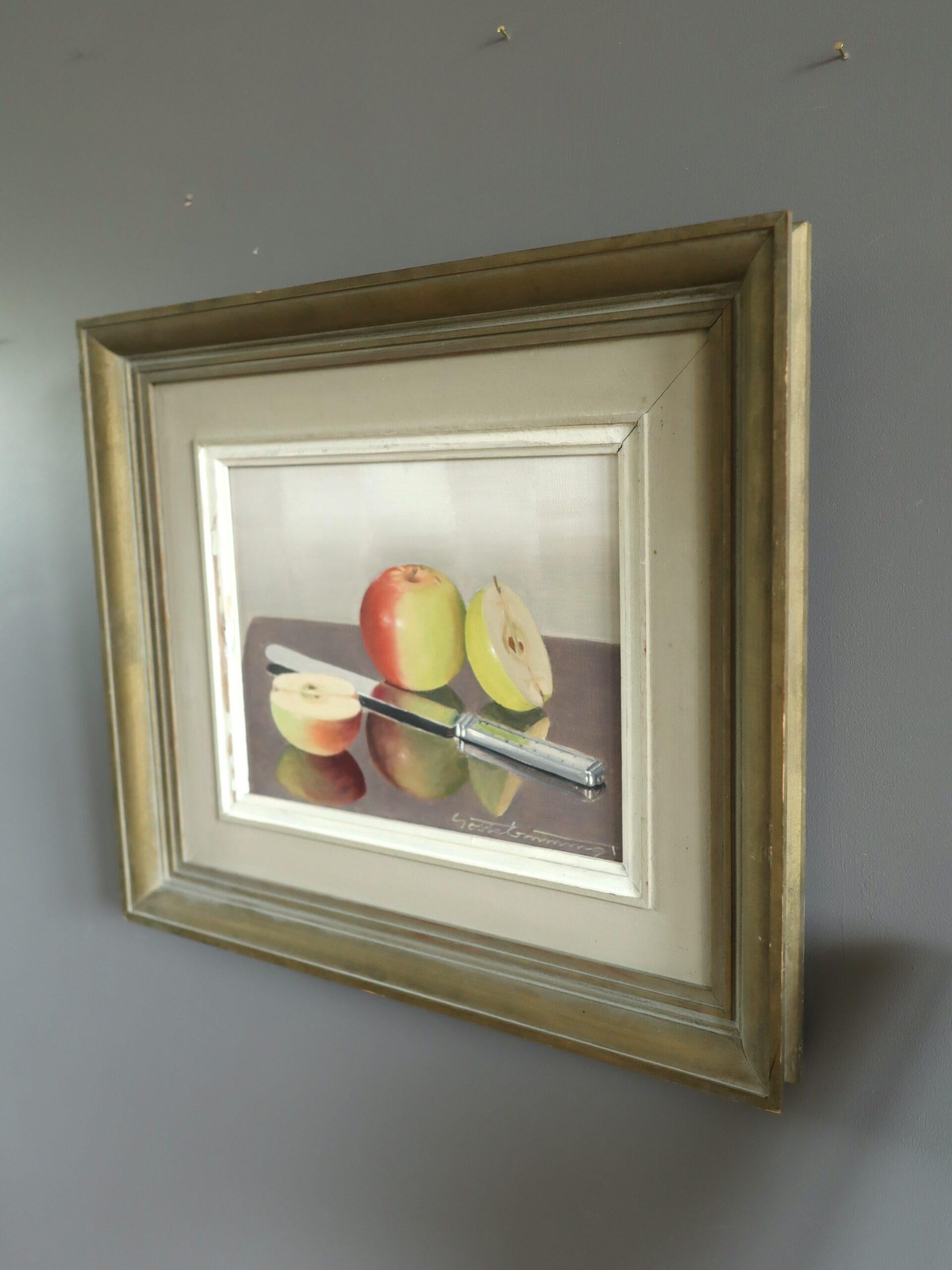 APFELREFLEXION
Größe: 34,5 x 39 cm (einschließlich Rahmen)
Öl auf Leinwand

Ein raffiniertes Stillleben aus der Mitte des Jahrhunderts, das einen klaren Moment häuslicher Einfachheit mit fotorealistischer Präzision einfängt, ausgeführt in Öl auf