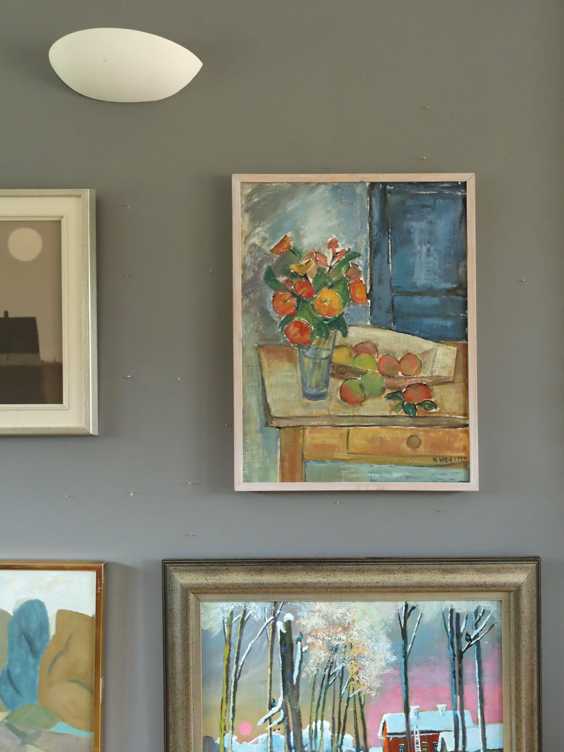 INTERIOR WITH FRUIT
Size: 63.5 x 49 cm (including frame)
Oil on canvas

A charming and vibrant mid-century interior still life that captures a sunlit domestic scene through bold yet lyrical brushwork, executed in oil onto canvas.

A glass vase