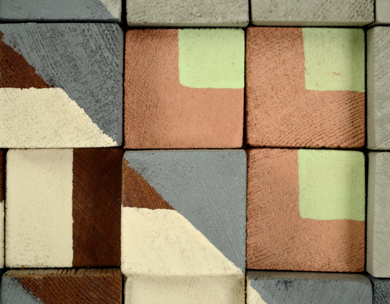 Clean and contemporary abstract geometric painted wooden block wall art by an unknown artist (American, b.20th Century). This unique three-dimensional piece is comprised of small wooden blocks of varying heights, hand painted with minimalist