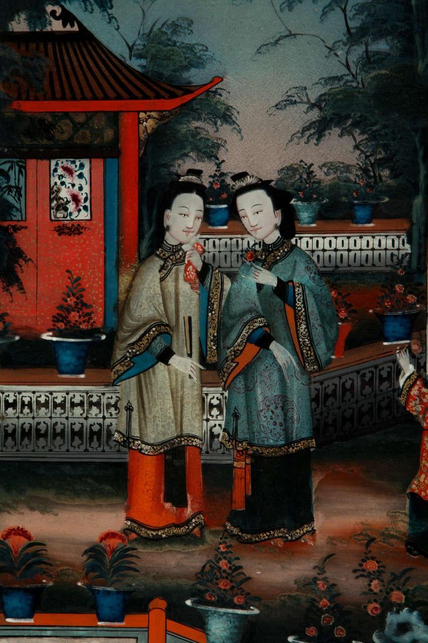 Une paire de peintures chinoises en verre inversé représentant des femmes et un enfant dans un pavillon de jardin. Encadrement original 