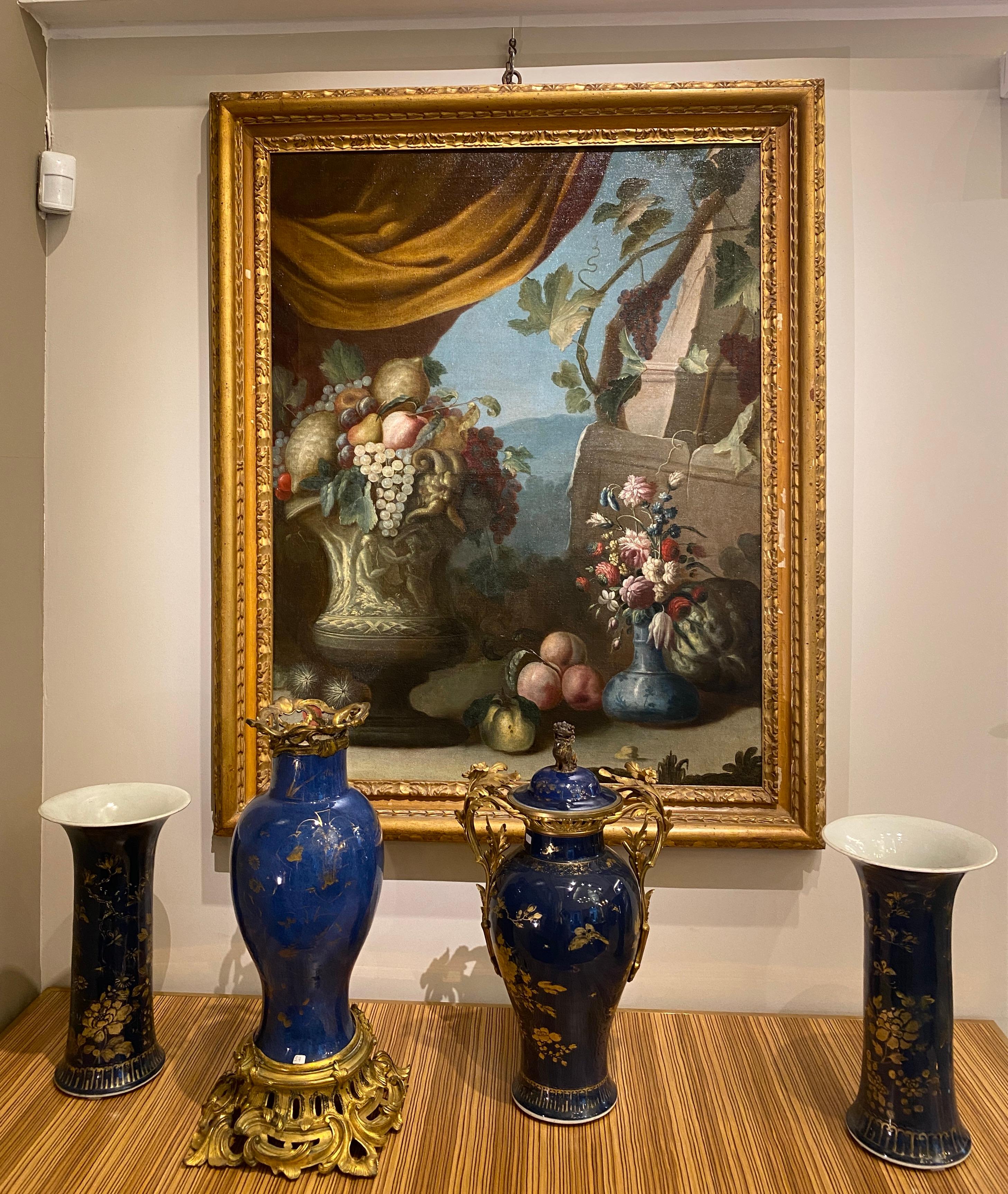 
This pair of excellent  Italian still life oil on canvas with flowers and fruit with classical ruins on the background and colored drapes create harmony of the composition. Notable are the beautiful Renaissance vases in the foreground .
The two