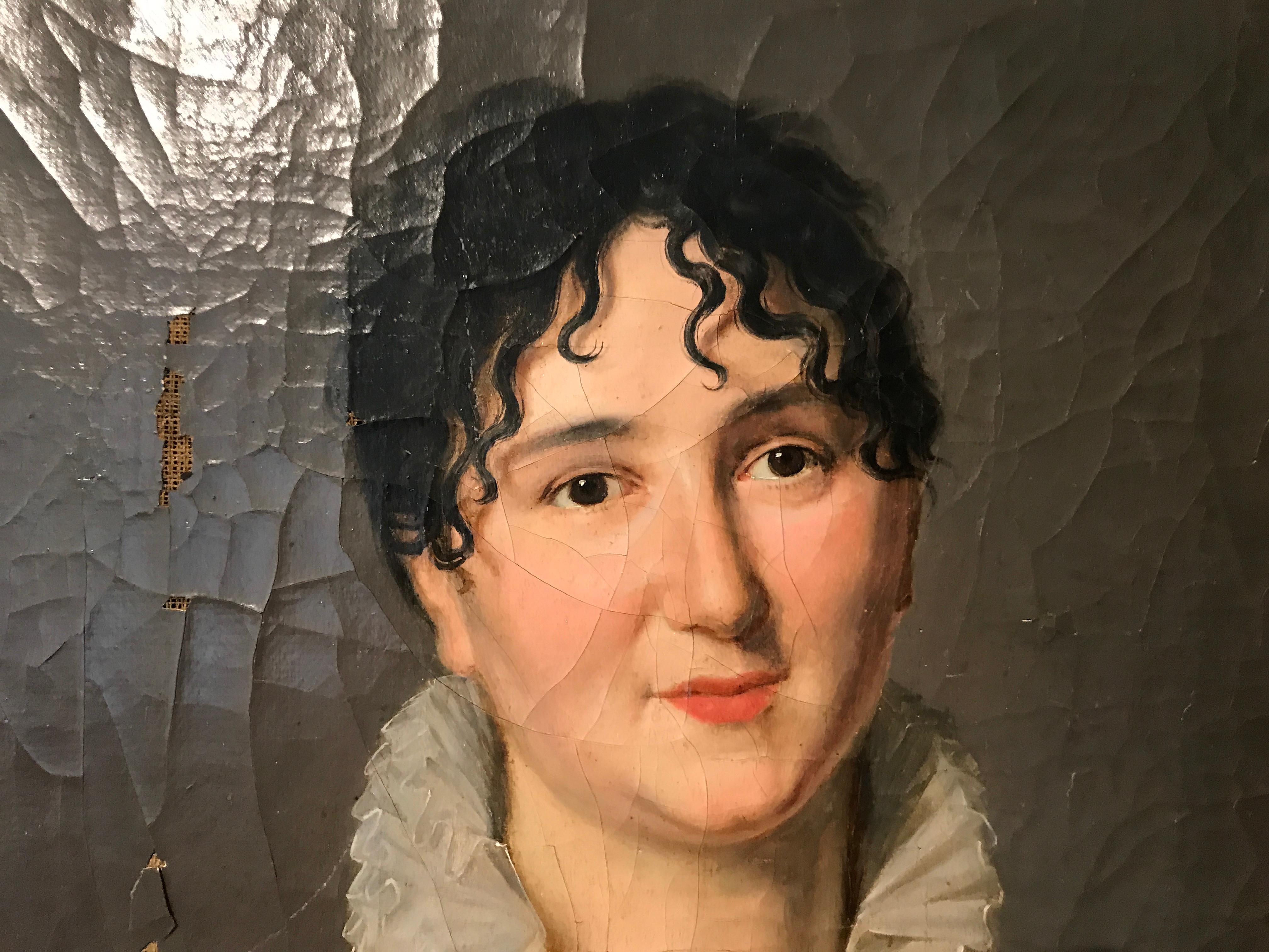 Dipinto su uno sfondo neutro che permette al soggetto di risaltare magnificamente, questo olio figurativo su tela del XIX secolo presenta il ritratto di una donna, in posa frontale leggermente angolata e vestita con abiti bianchi e neri, con uno