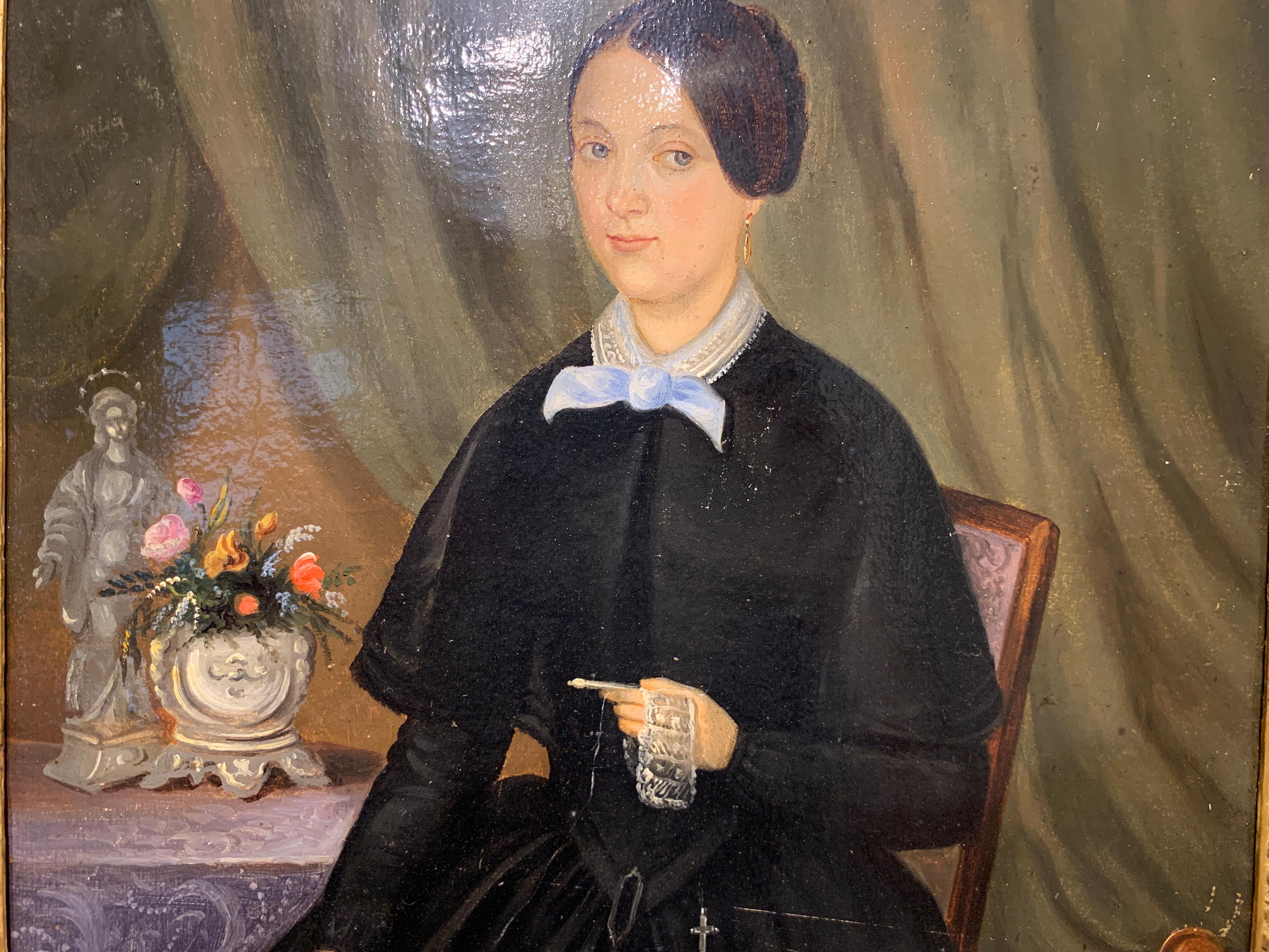 'Portrait of a Woman I' is a framed vertical oil on canvas painting depicting a 19th century woman sitting on a chair in front of a table, a large curtain behind her accentuating her presence. She is holding a lace embroidery work. Typical of