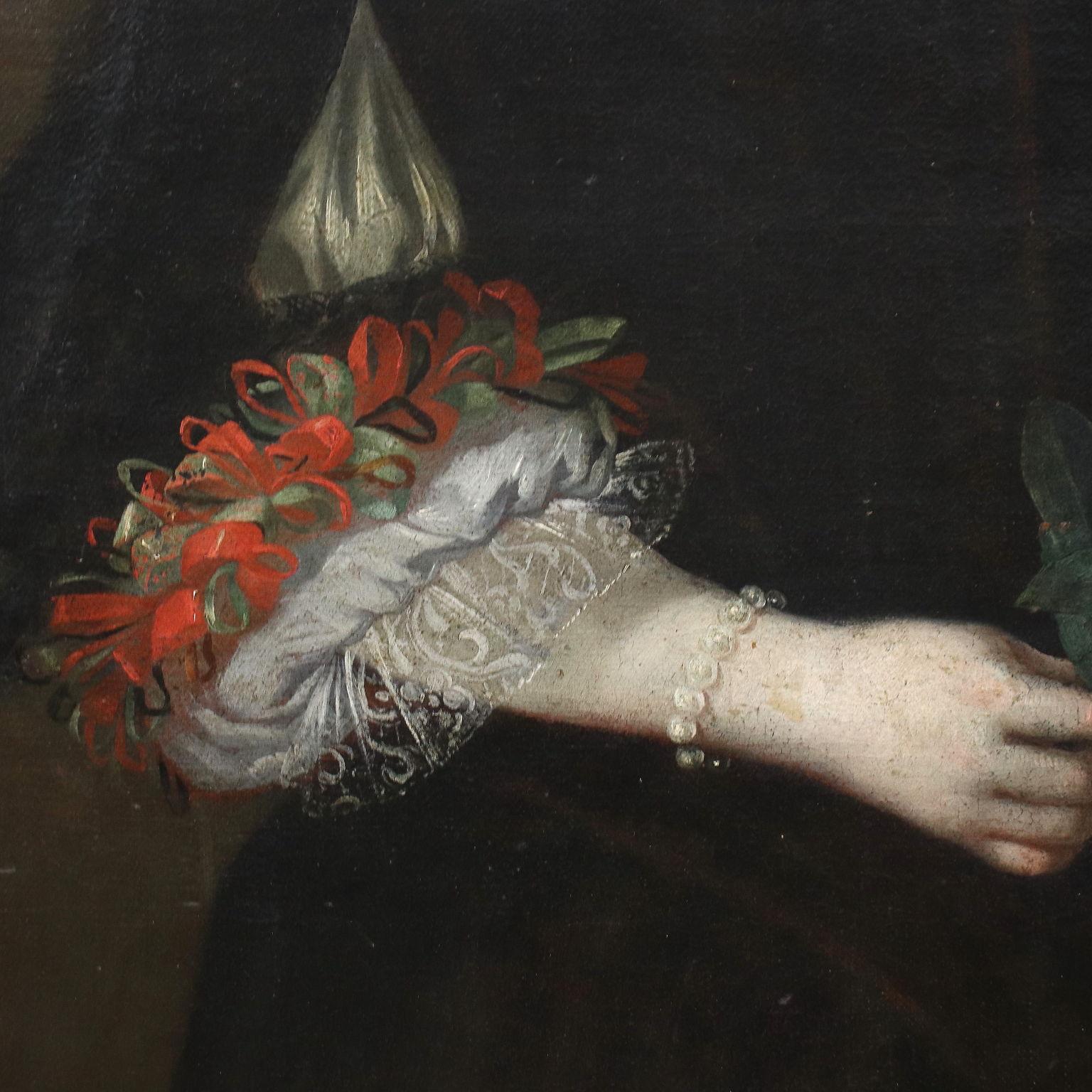 Ölgemälde auf Leinwand. Lombardische Schule des siebzehnten Jahrhunderts. Ein lächelndes junges Mädchen ist in einem eleganten schwarzen Kleid dargestellt, das am Dekolleté mit Spitze und an den Ärmeln mit einem Spiel aus roter und grüner Spitze und