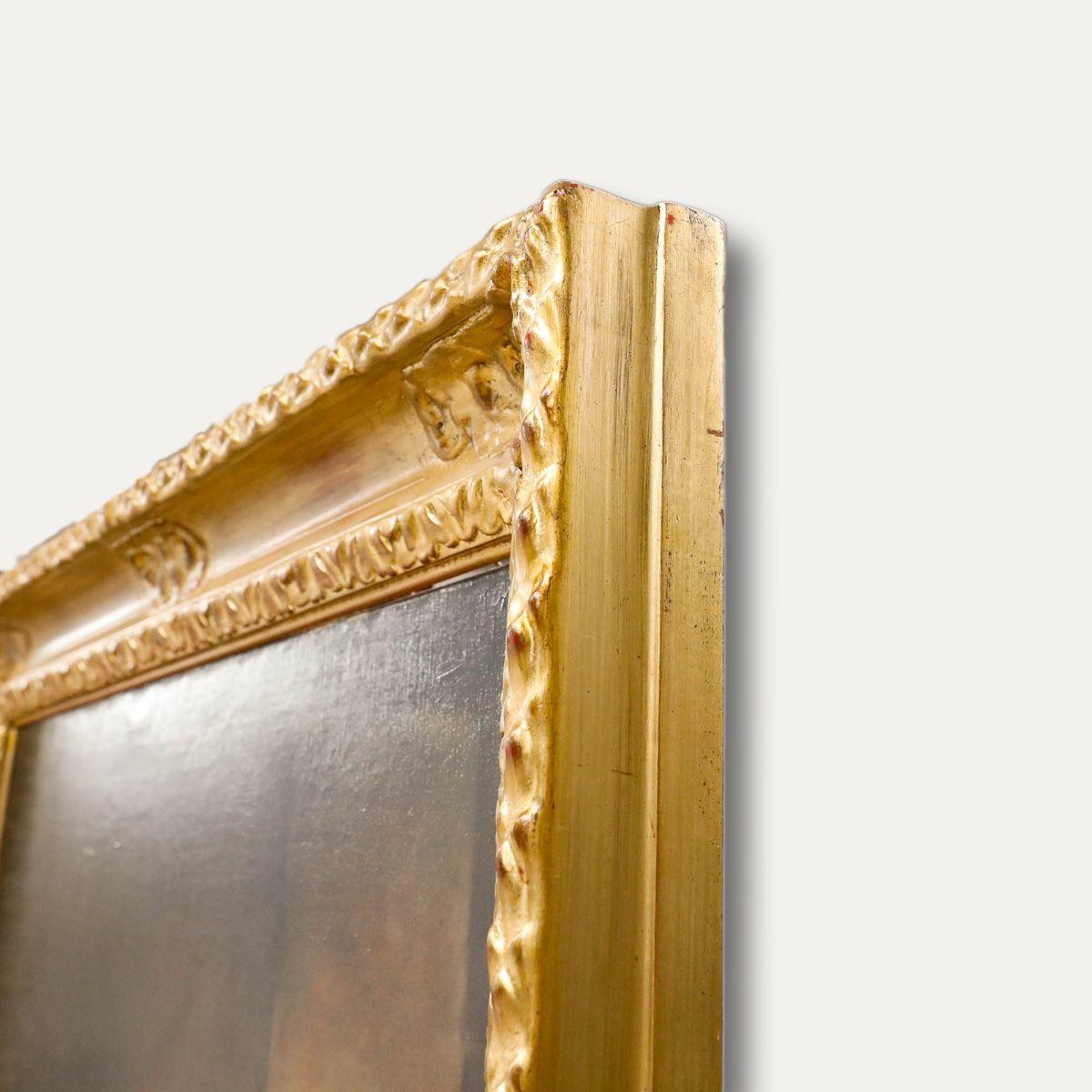 A charming late 19th-century genre scene depicting a lady in traditional dress spinning yarn beside a fire. The artist has rendered the figure in fine detail, paying close attention to the folds and textures of her dress. The overall tone of the