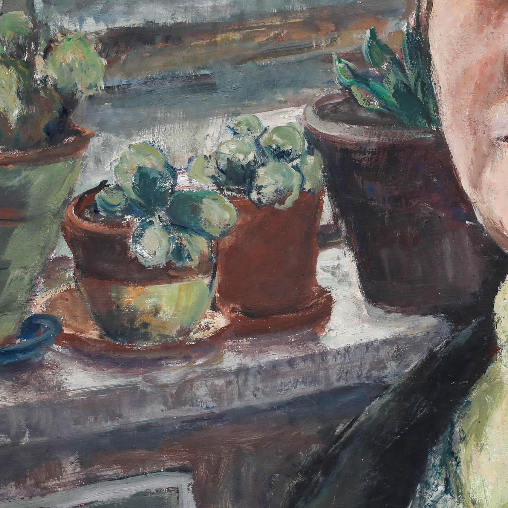 This intimate portrait captures an artist in their studio, surrounded by the tools of their trade. The muted colour palette and soft lighting create a contemplative atmosphere, drawing the viewer's focus to the subject's intense gaze and the