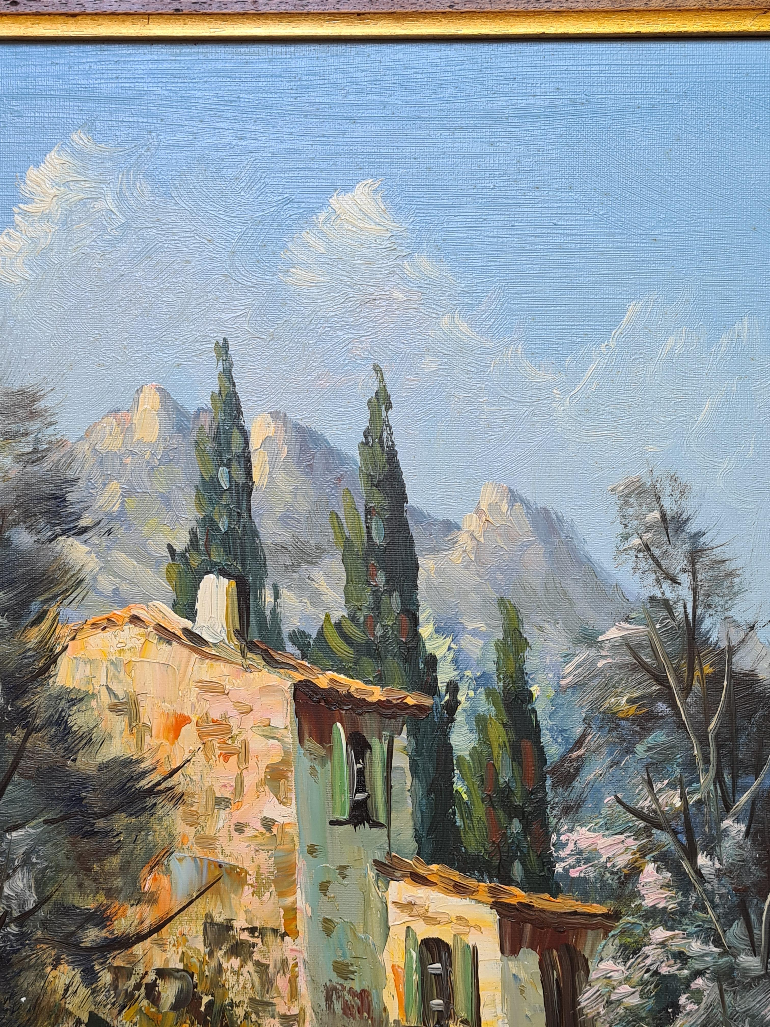 Une huile sur toile représentant une maison en pierre dans un paysage avec des collines au loin. Le tableau est signé en bas à droite, mais la signature n'a pas encore été déchiffrée. L'œuvre est présentée dans un cadre simple en bois avec filet