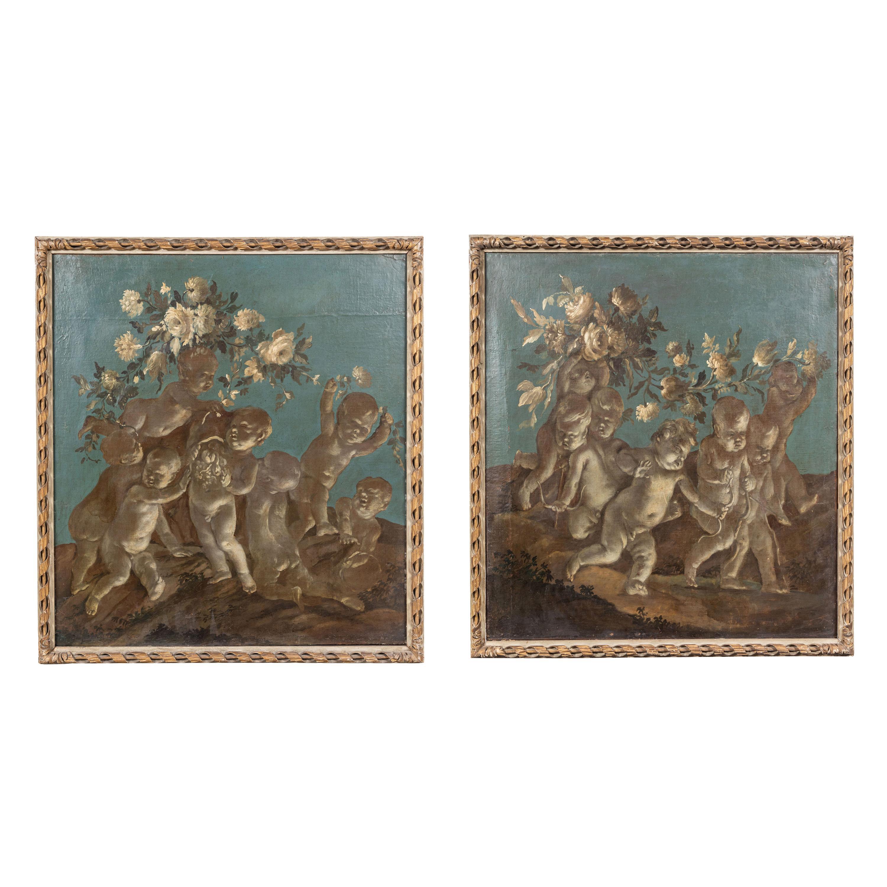A chic pair of Roman, oil-on-canvas overdoor paintings done in a nocturne, grisaille style. Each featuring underlit cherubs at play amongst streaming garlands of blooming flowers, all against a rich, indigo sky.

Note: The pair have slightly