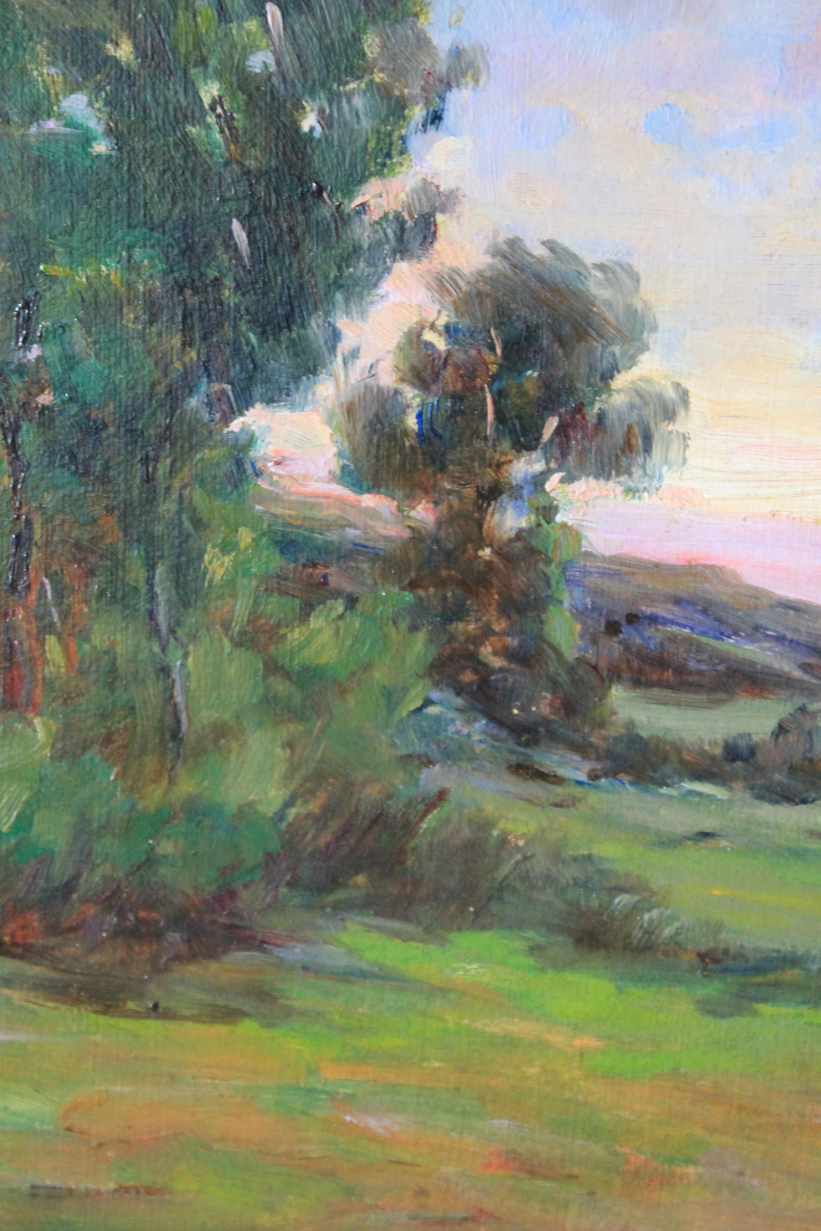 French vintage oil painting on board in an old gold coloured heavy frame  This  attractive painting shows a sunset in a French landscape.  With a luminated sky of blues and purples against a traditional green and brown country landscape, this