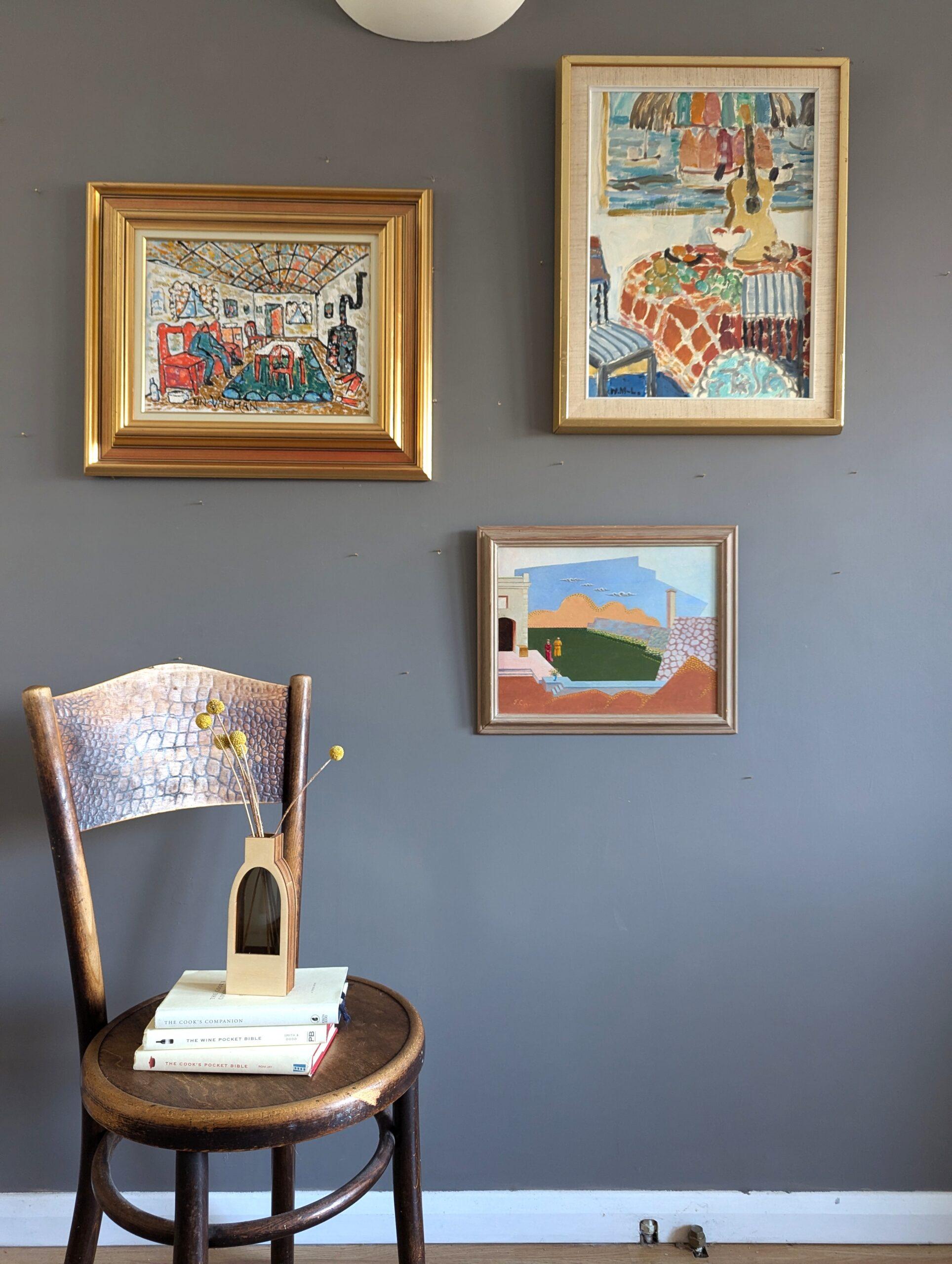 INTERIOR WITH PAINTING
Size: 57 x 45 cm (including frame)
Oil on board

An expressive and uplifting mid-century modernist painting that showcases a richly decorated interior scene, executed in oil onto board.

The composition features a still life