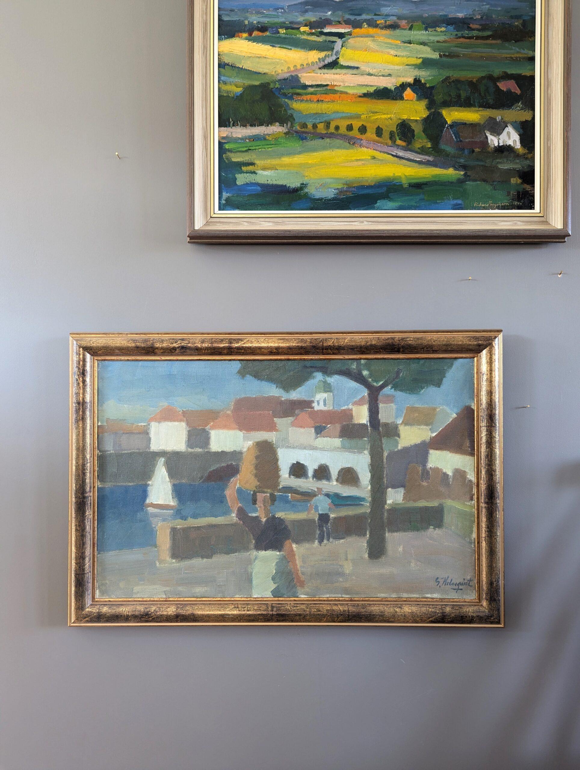 RIVERSIDE TOWN
Size: 42 x 61.5 cm (including frame)
Oil on canvas

A serene and charming mid-century modernist riverside townscape, executed in oil onto canvas.

The composition presents a scene of everyday life, featuring a figure in the