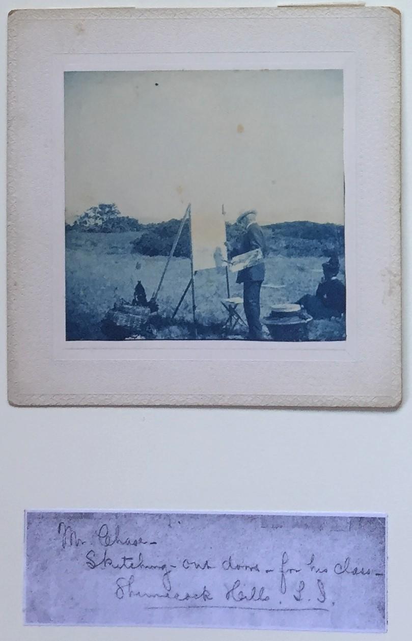 William Merritt Chase's Classes at Shinnecock Hills, Long Island.
Photographer not identified. 4 Cyanotypes. c. 1900.
1.Mr. Chase Criticising a pupil. Cyanotype. c. 1900. 3 3/16 x 3 3/8 (original mount 5 x 4 7/8). Hinged on 12 x 8 3/4-inch archival