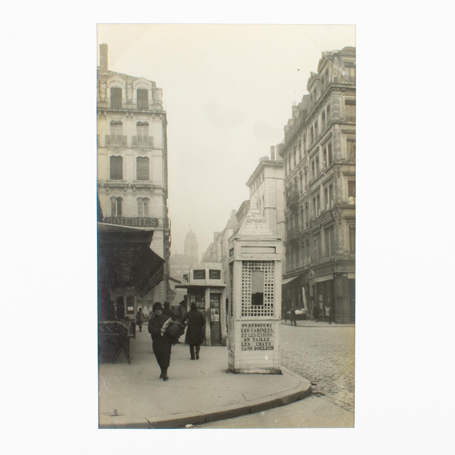 A unique original silver gelatin black and white photography. The Town Hall street in Lyon, France, March 1927. 
A view of the town hall street in Lyon, France, dated March 13th, 1927. Note the weird inscription on the newsstand: 
