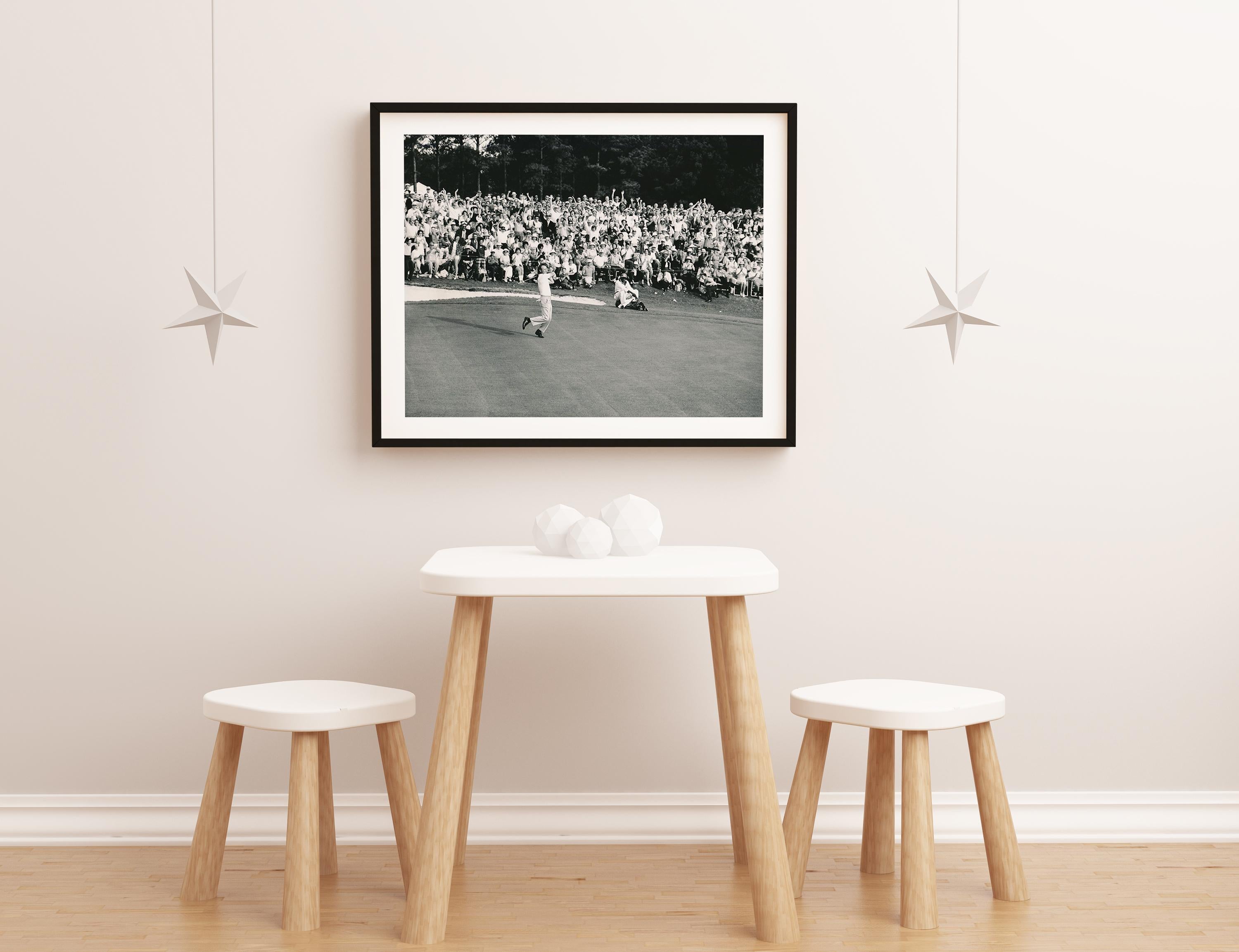 This black and white action shot features Arnold Palmer playing golf, taking a swing as the crowd looks on.

Arnold Palmer was an American professional golfer who is generally regarded as one of the greatest and most charismatic players in the