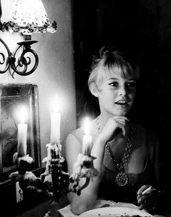 Brigitte Bardot che fuma davanti a un candelabro